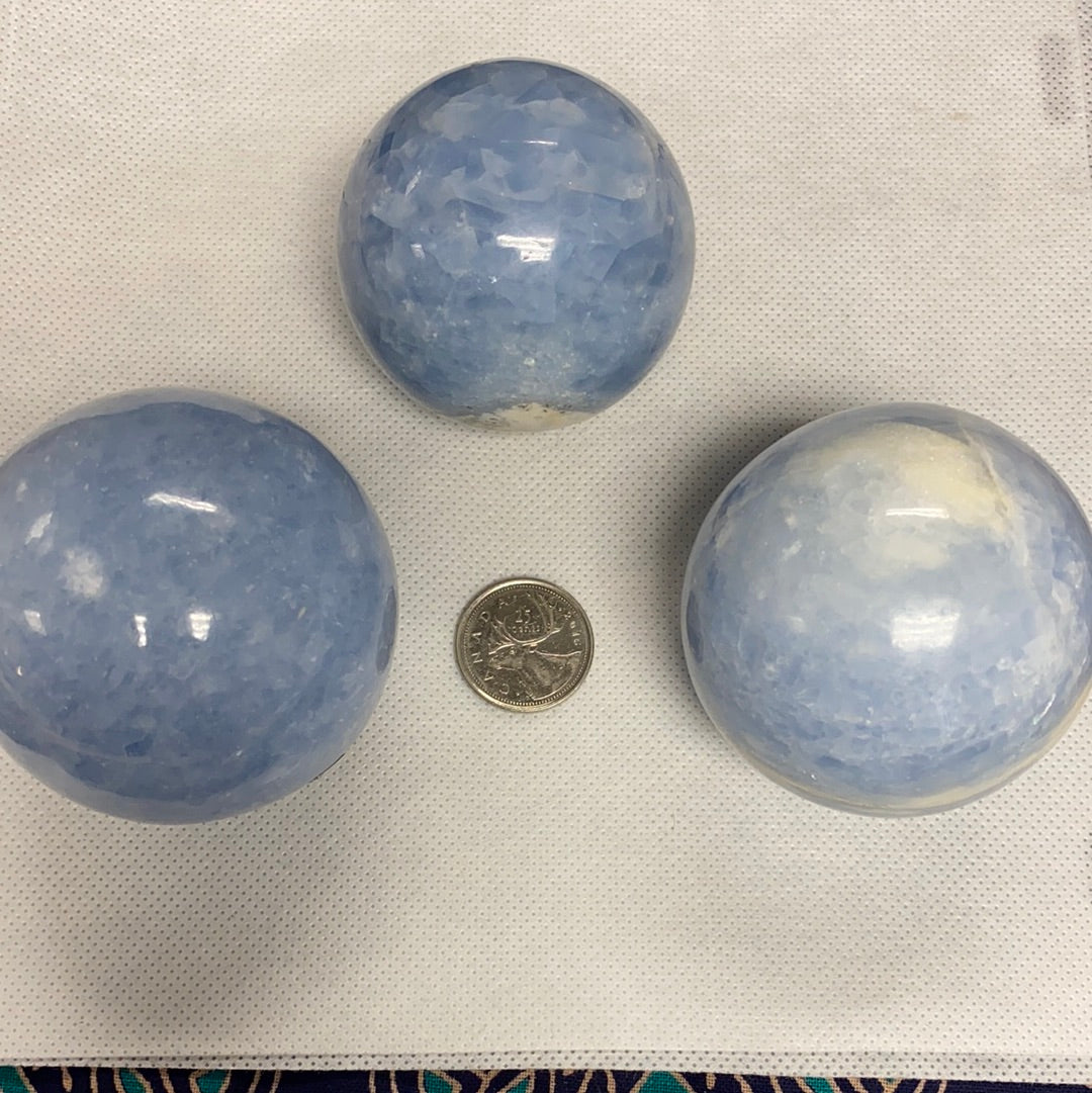 A collection of blue calcite spheres showcasing various shapes and sizes, radiating calming energy.