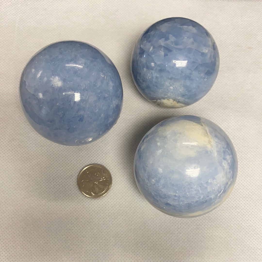 A collection of blue calcite spheres showcasing various shapes and sizes, radiating calming energy.