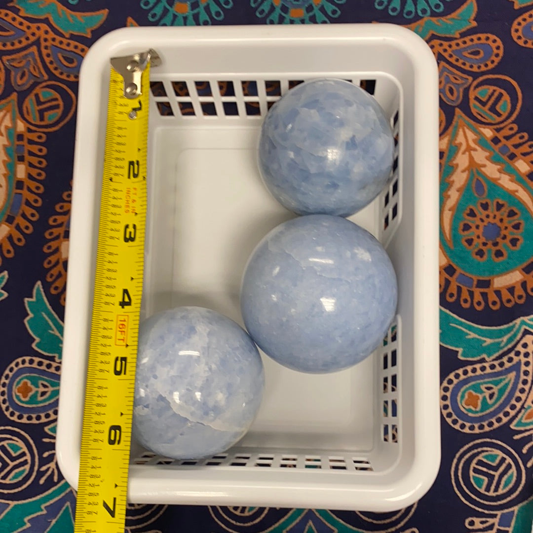 A collection of blue calcite spheres showcasing various shapes and sizes, radiating calming energy.