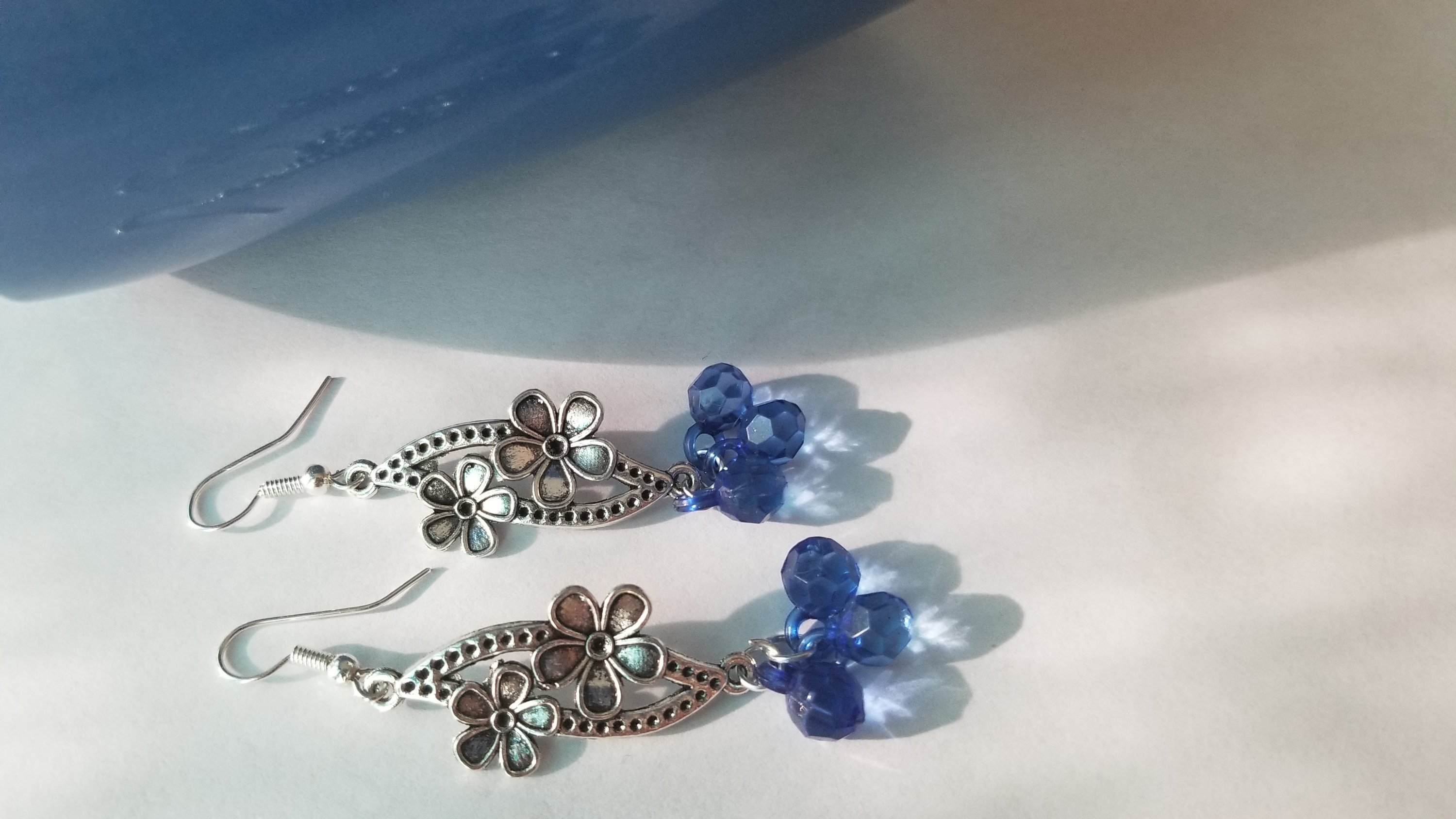 A pair of elegant blue earrings with a translucent finish, showcasing their unique design and shimmering quality.