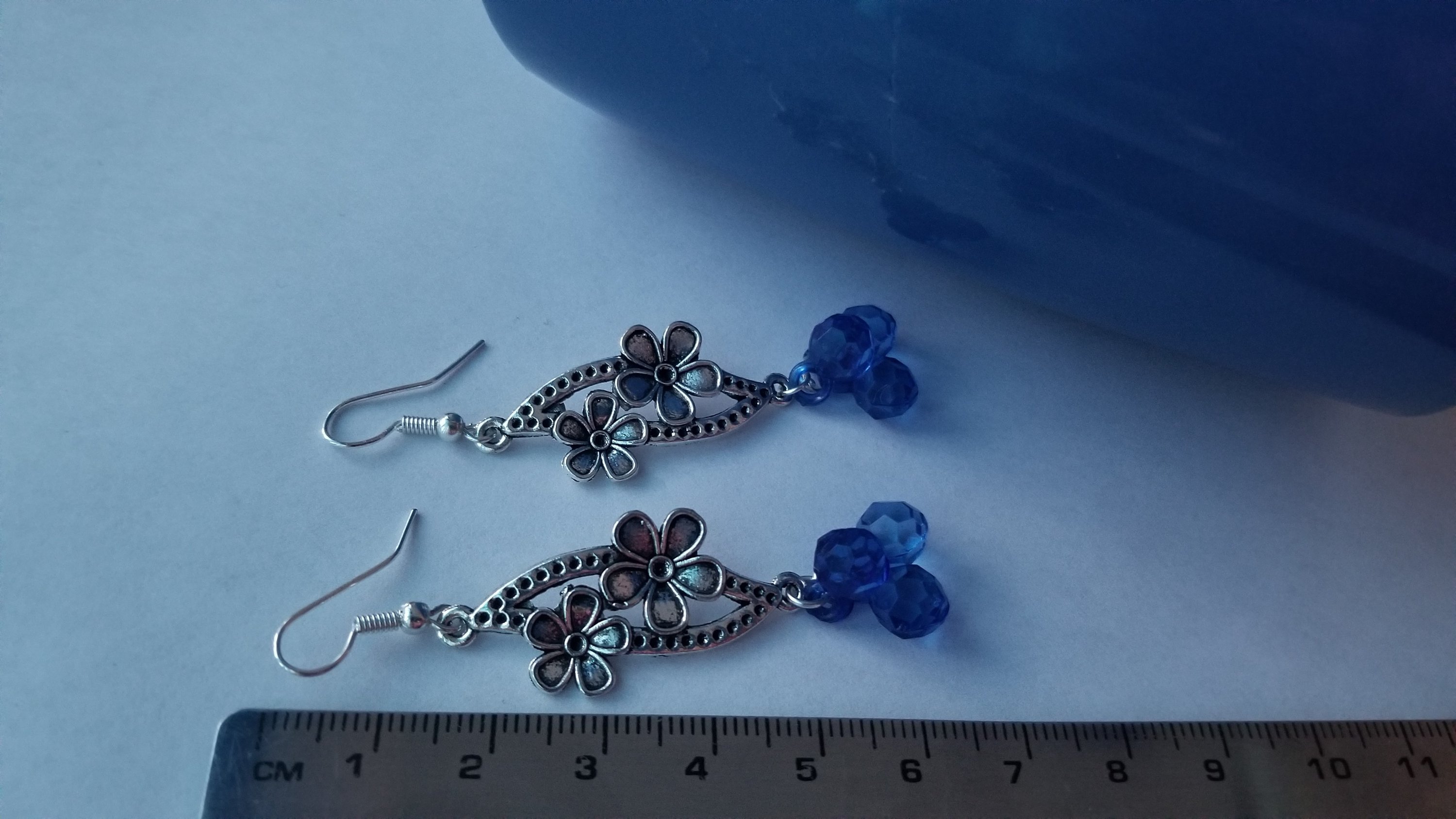 A pair of elegant blue earrings with a translucent finish, showcasing their unique design and shimmering quality.