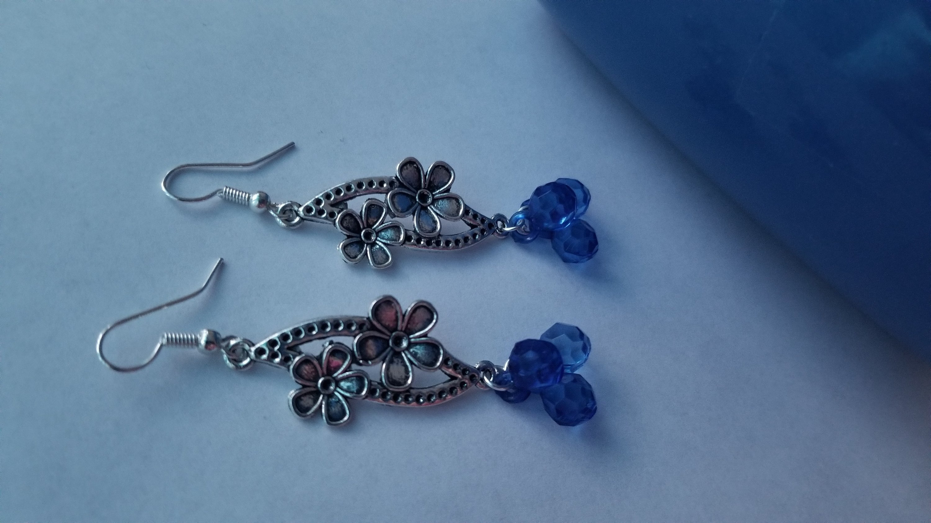 A pair of elegant blue earrings with a translucent finish, showcasing their unique design and shimmering quality.