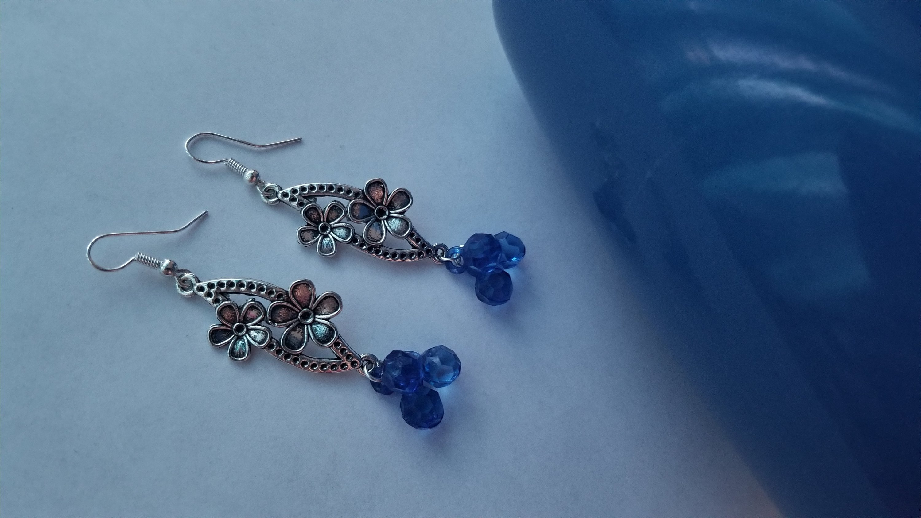 A pair of elegant blue earrings with a translucent finish, showcasing their unique design and shimmering quality.