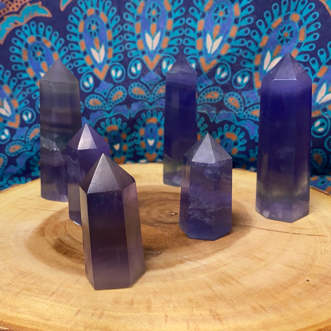 A collection of Blue Fluorite Polished Points showcasing unique shapes and vibrant blue hues, reflecting light beautifully.