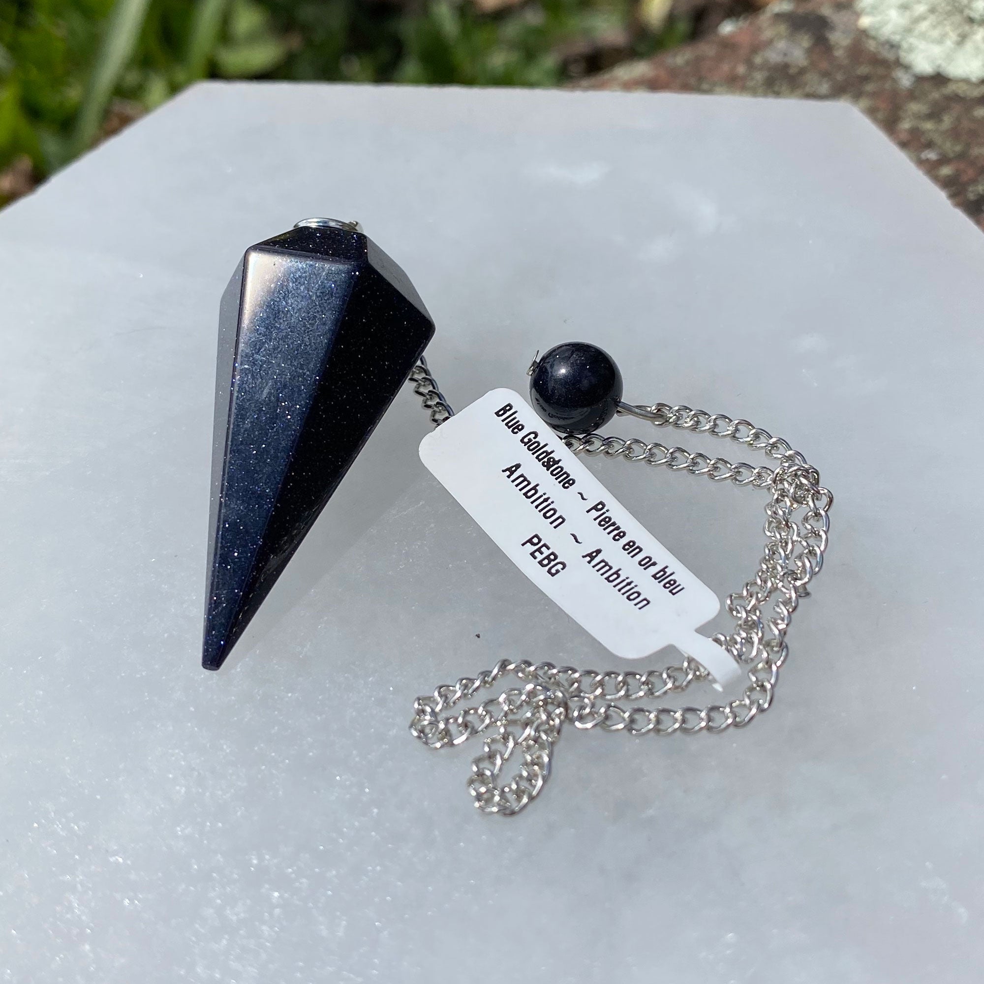 A beautiful Blue Goldstone Pendulum on a silver chain, showcasing its shimmering blue surface and unique gemstone properties.