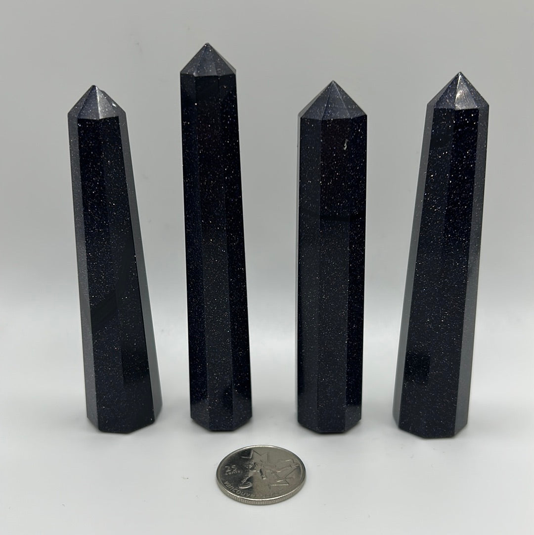 A polished Blue Goldstone point, showcasing its unique shimmering surface and natural gemstone characteristics.