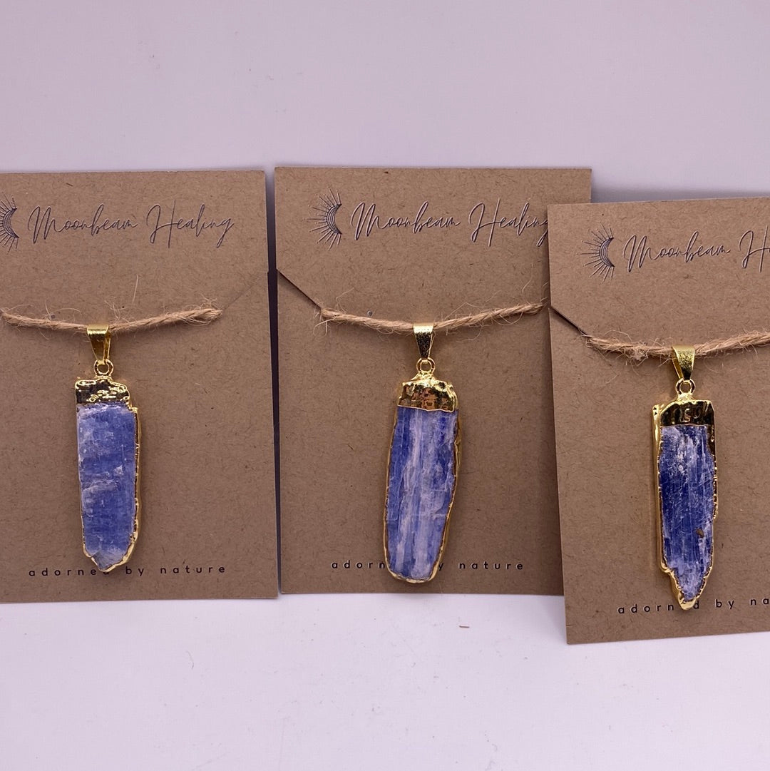 A beautiful Blue Kyanite pendant with a gold electroplated frame, showcasing its unique twisted fibrous structure.