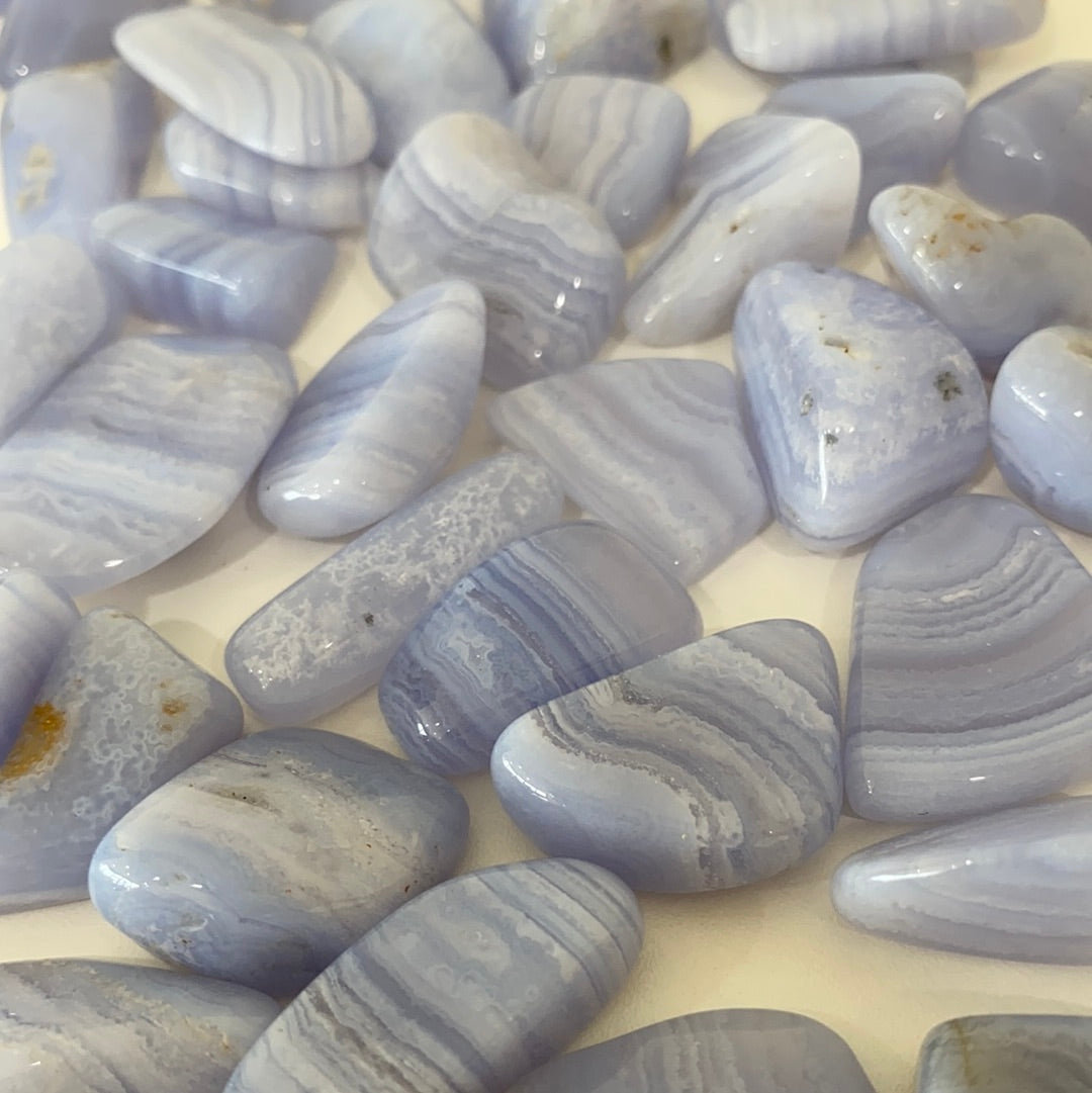 A collection of Blue Lace Agate Tumbled Healing Stones showcasing their unique blue and white lace patterns, perfect for healing and meditation.