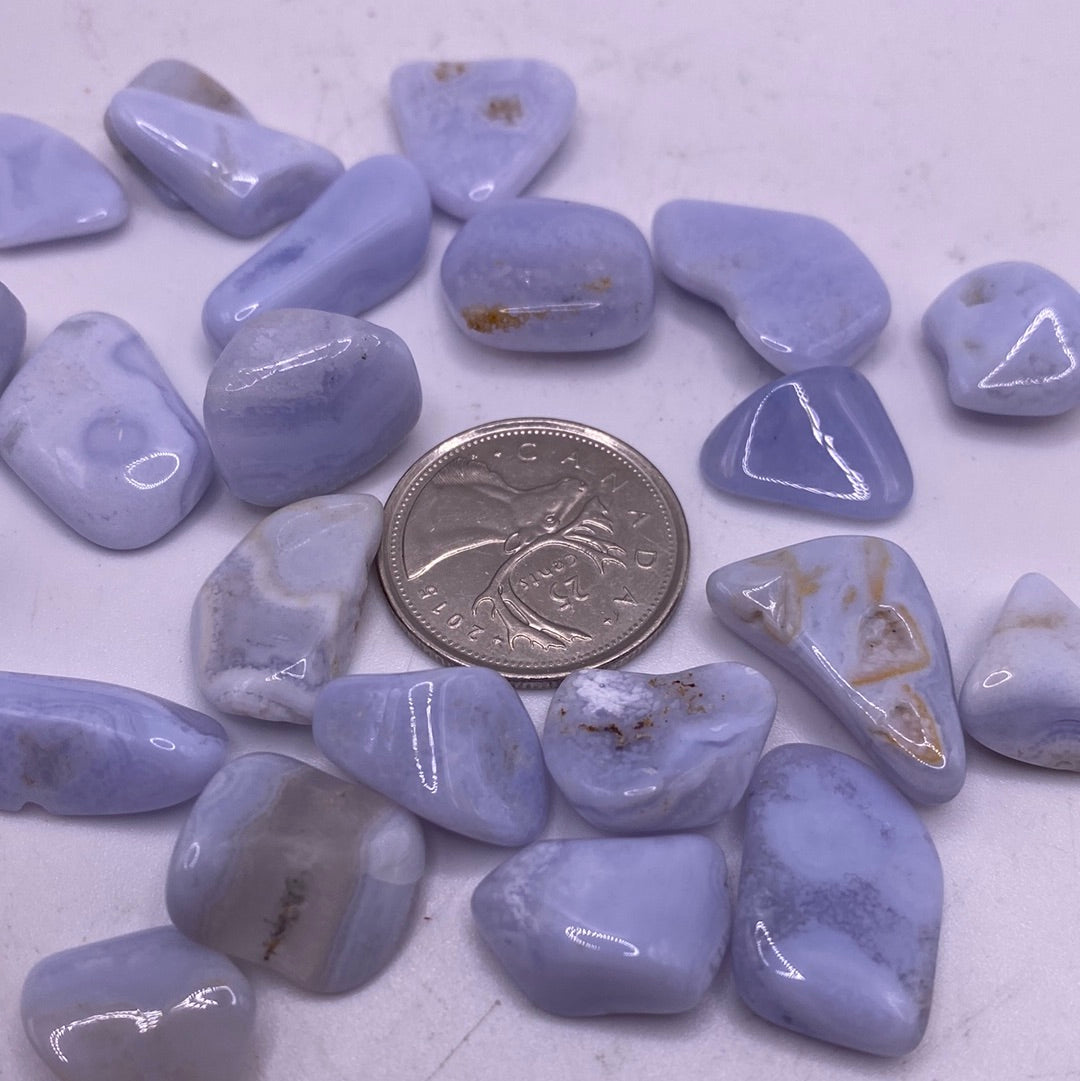 A bag of Blue Lace Agate Tumbled stones showcasing their unique blue and white lace patterns, perfect for healing and meditation.