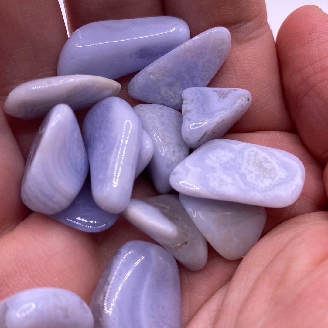 A bag of Blue Lace Agate Tumbled stones showcasing their unique blue and white lace patterns, perfect for healing and meditation.