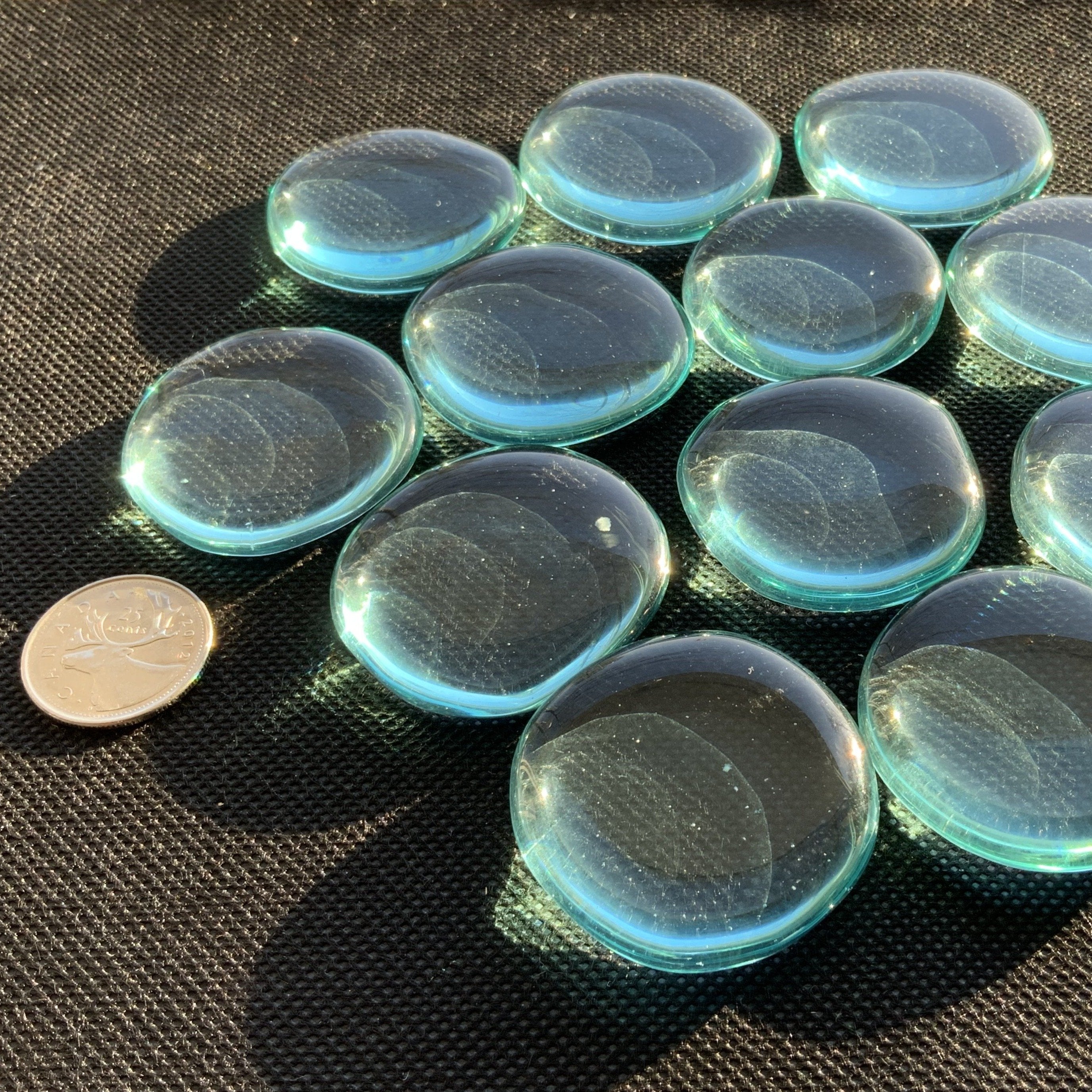 A collection of smooth, polished Blue Obsidian Palm Stones showcasing their vibrant blue color and glossy finish.