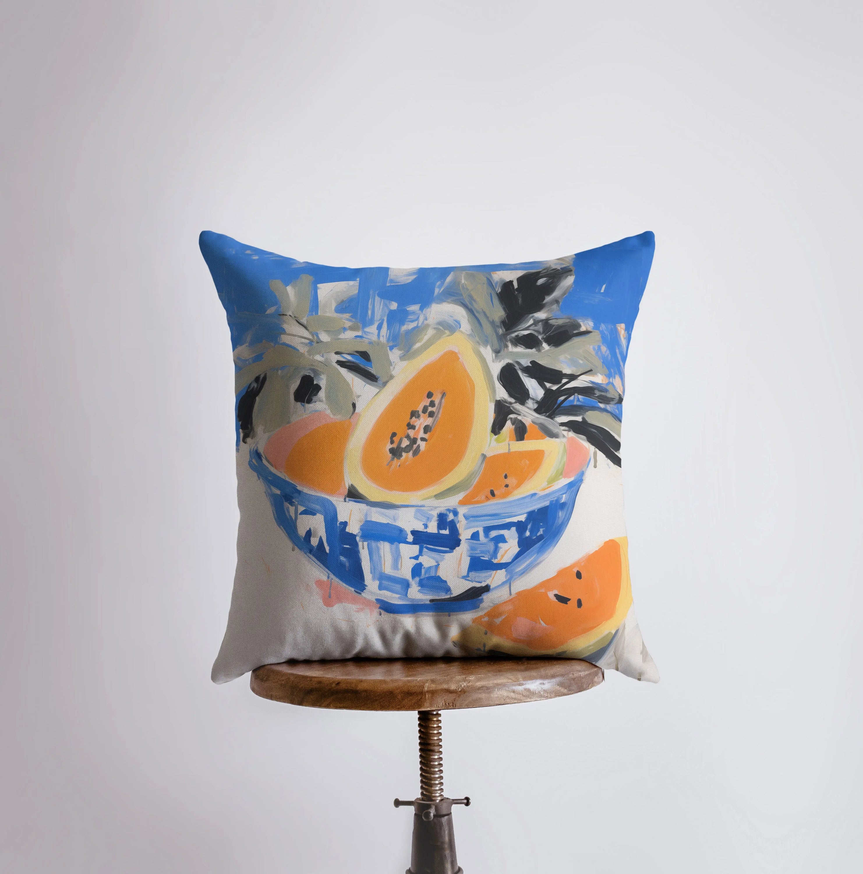 A vibrant blue papaya bowl pillow featuring a gouache painting, showcasing a colorful fruit design on a cotton/polyester blend fabric.