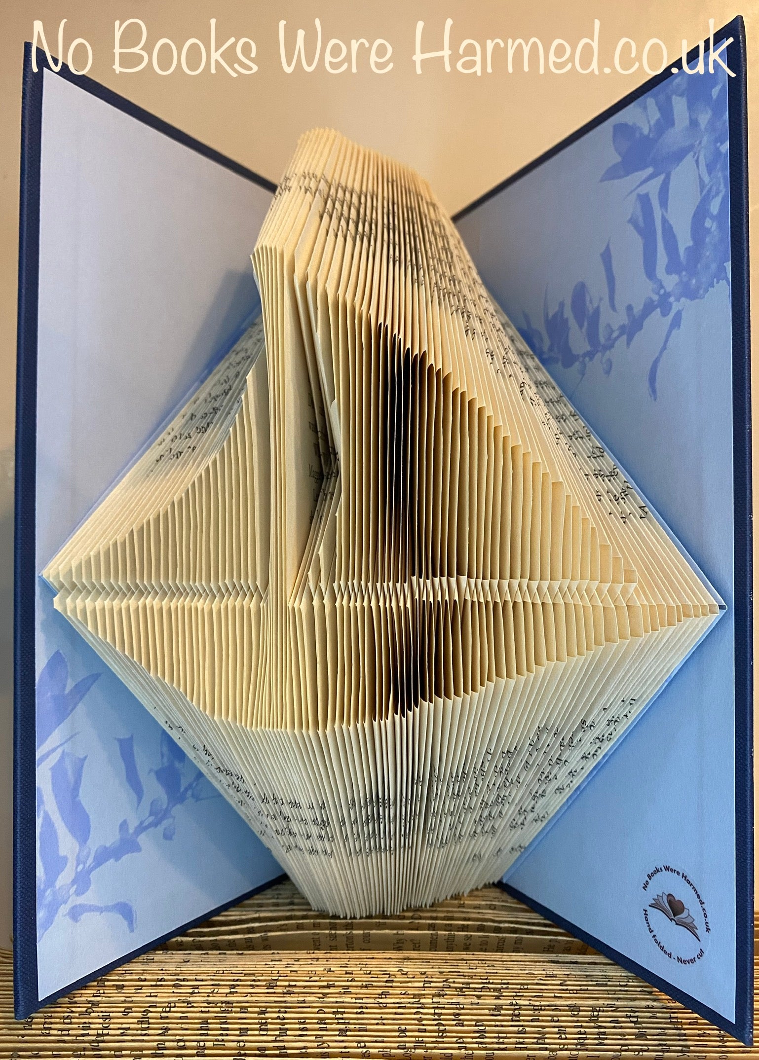 Handcrafted nautical book art made from vintage books, featuring unique designs and colors.