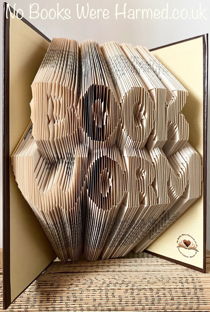 Handcrafted Book Worm art made from vintage books, showcasing intricate hand-folded pages in a unique design.