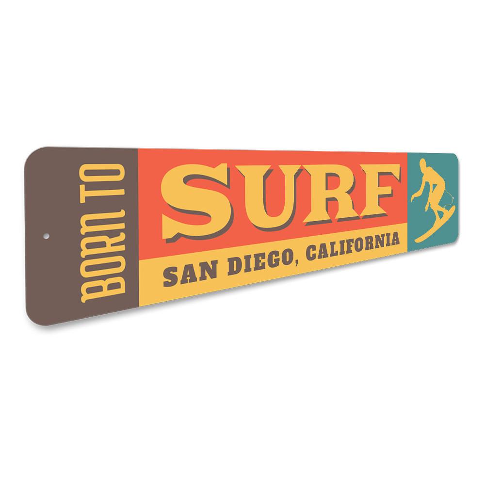 A decorative 'Born to Surf' sign made of durable aluminum, featuring vibrant colors and a beach-themed design, perfect for surf enthusiasts.