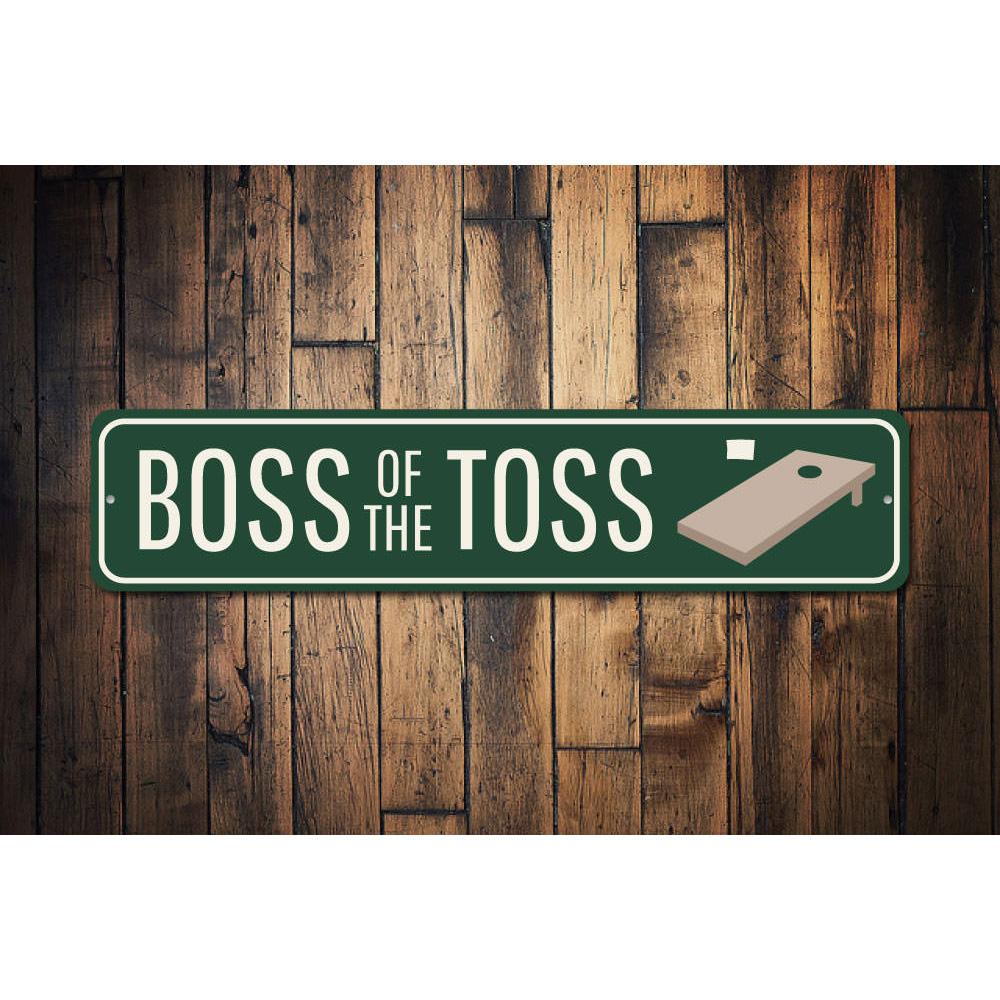 A decorative Boss of the Toss Sign made from high-quality aluminum, featuring customizable text and pre-drilled holes for easy mounting.