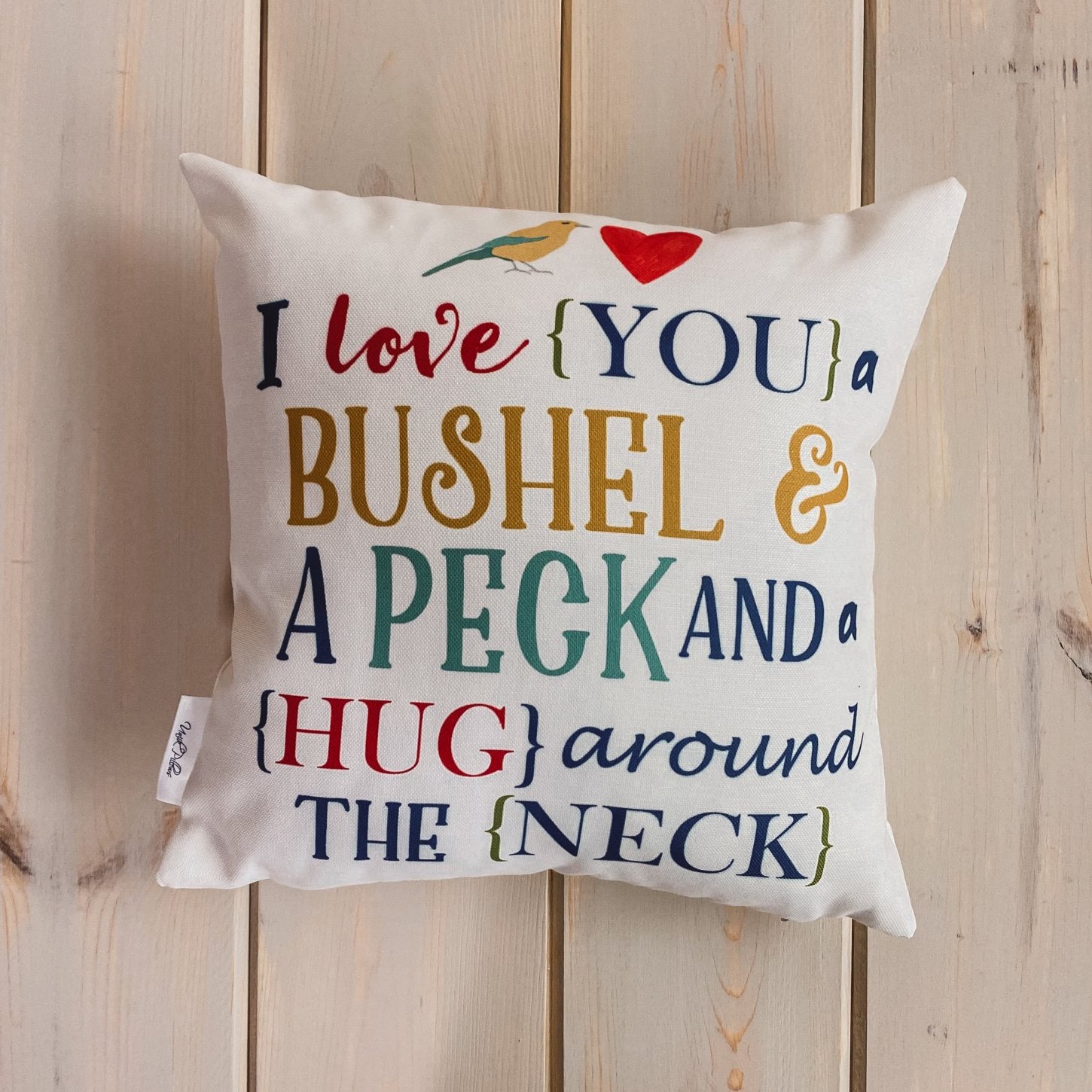 Bushel and a Peck pillow cover featuring colorful lettering on a white background, showcasing a heartfelt design.