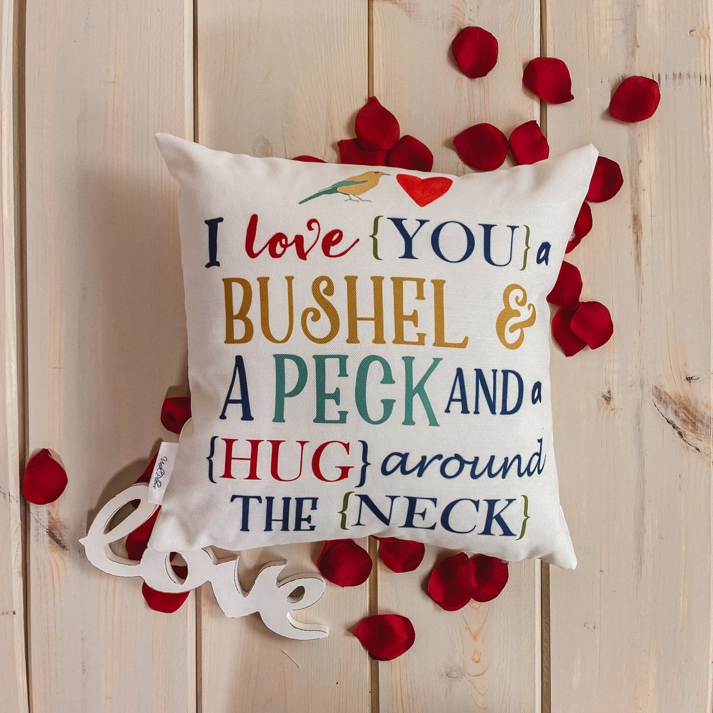 Bushel and a Peck pillow cover featuring colorful lettering on a white background, showcasing a heartfelt design.