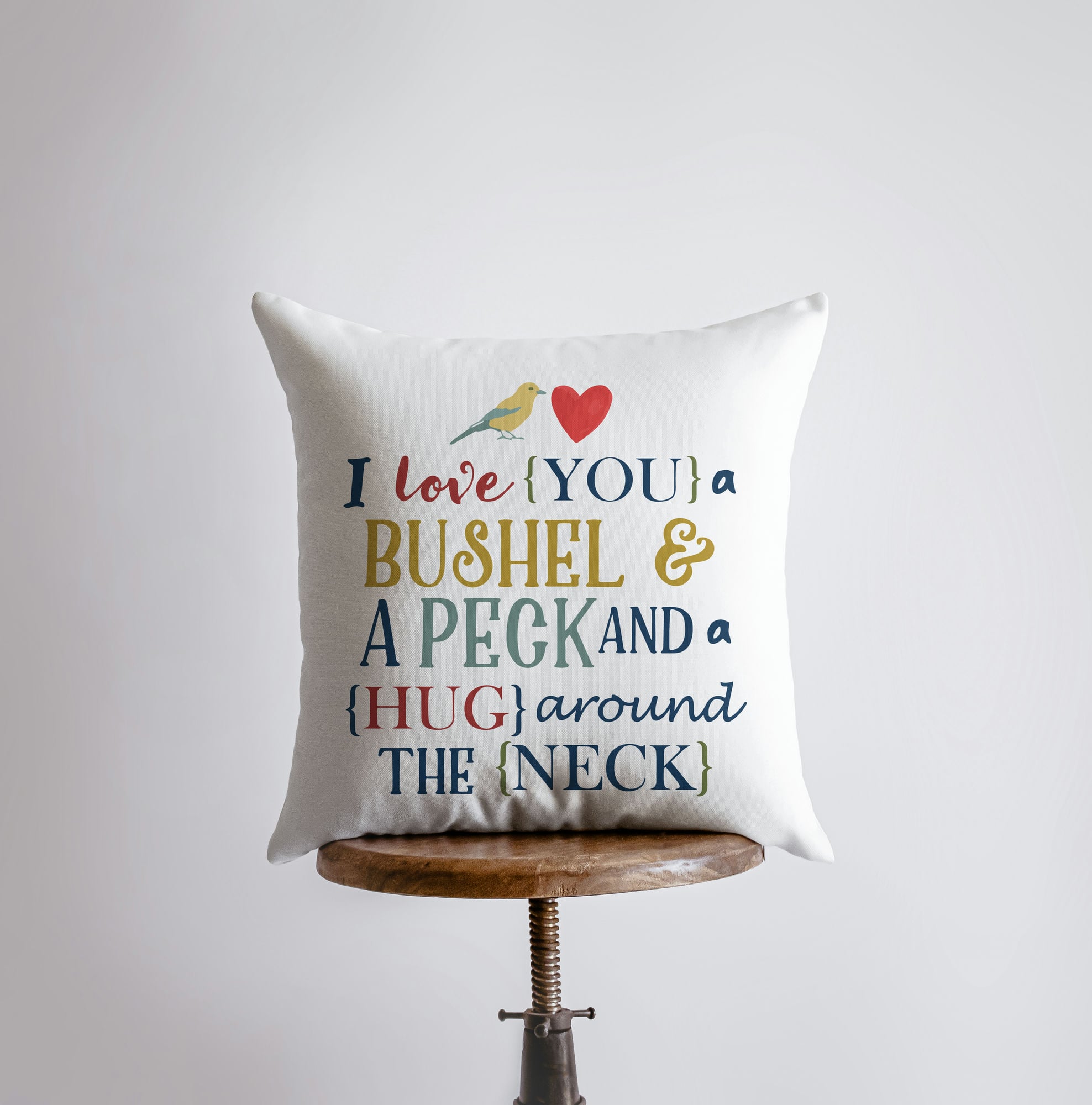 Bushel and a Peck pillow cover featuring colorful lettering on a white background, showcasing a heartfelt design.