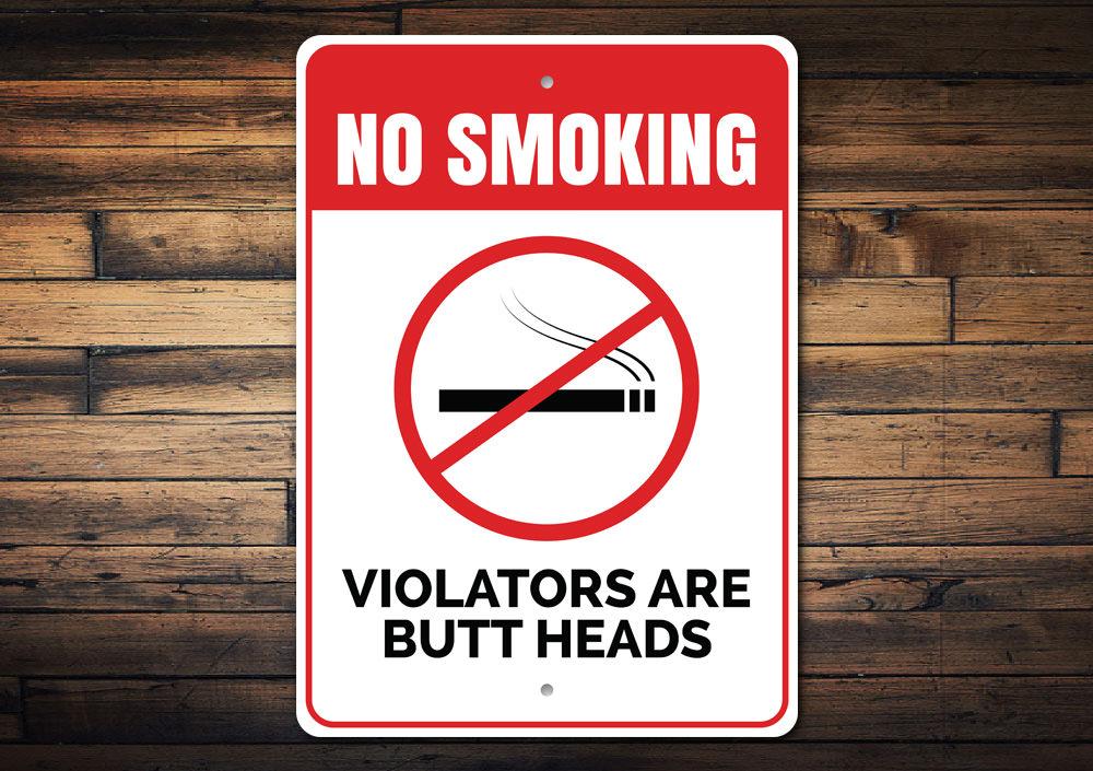 Butt Heads Smoking Sign featuring humorous text on a decorative aluminum background, ideal for man caves and home decor.