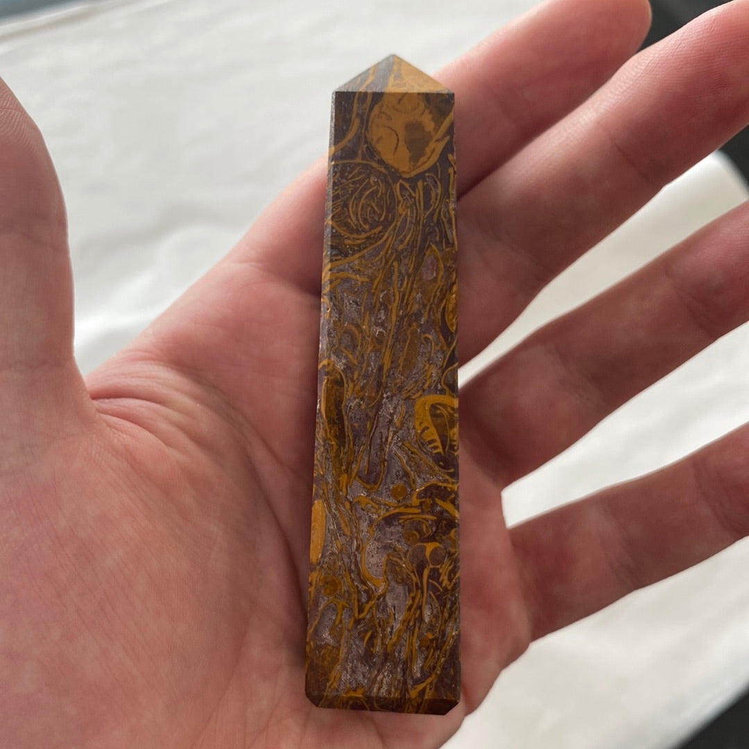 A beautiful Calligraphy Stone Obelisk with unique banded patterns in white, gray, and brown, showcasing its smooth texture and spiritual significance.