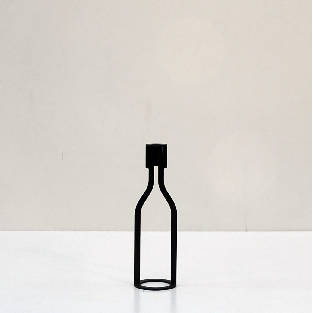 THE BOTTLE candlestick designed by Peter van de Water, featuring a sleek industrial steel design with a black matte finish.