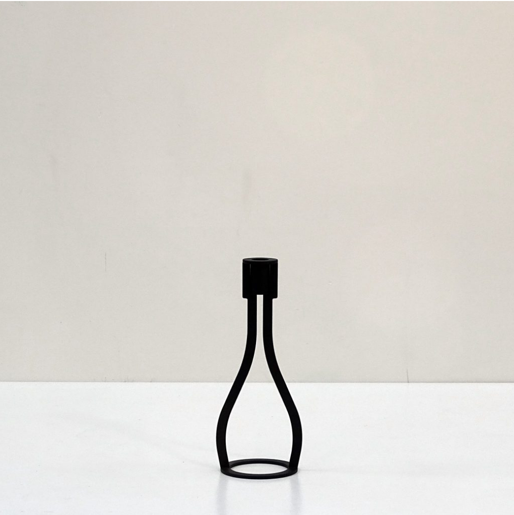 THE BOTTLE candlestick designed by Peter van de Water, featuring a sleek industrial steel design with a black matte finish.