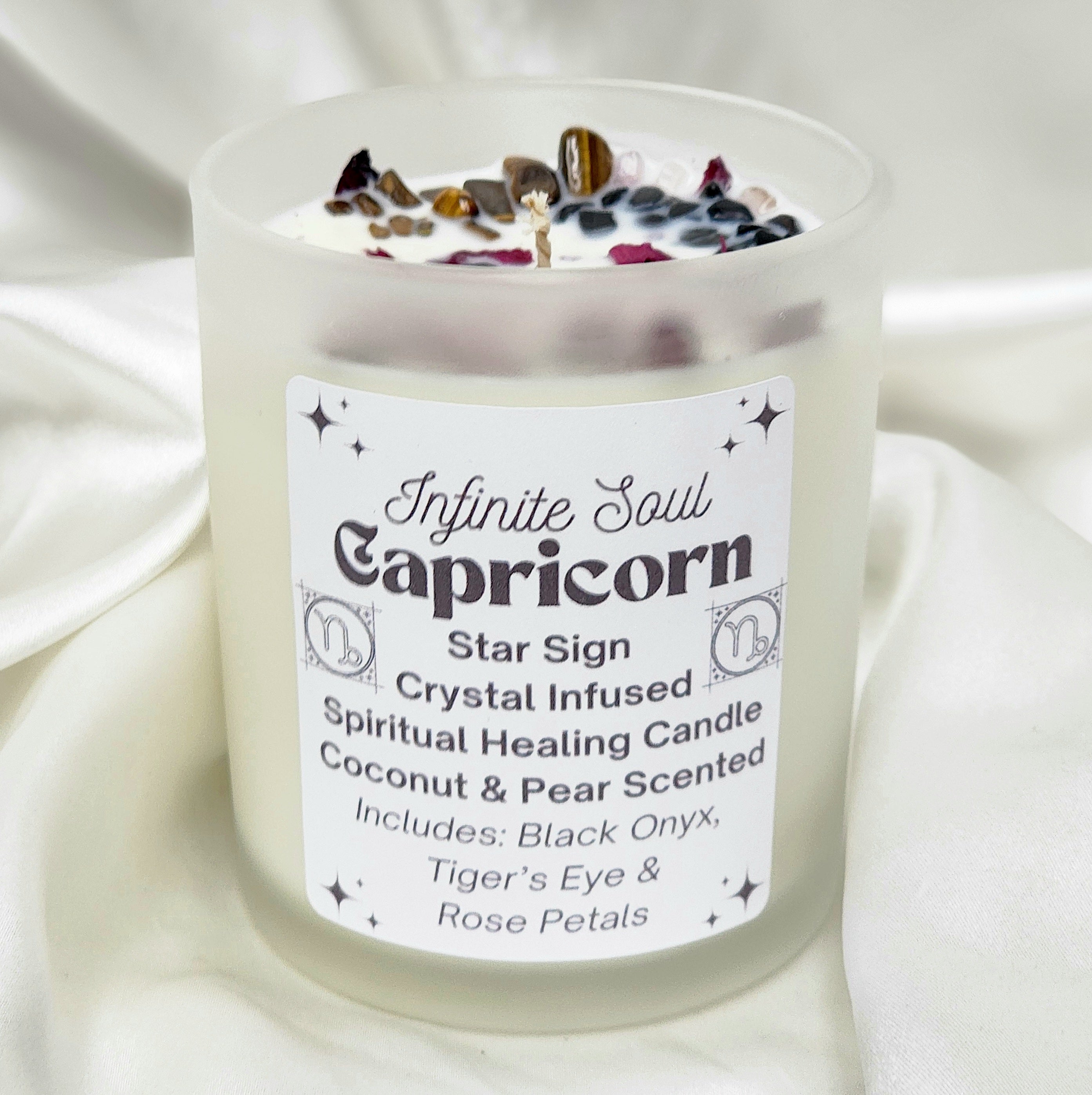 Capricorn Star Sign Crystal Infused Candle with Coconut & Pear scent, featuring Black Onyx and Tiger's Eye crystals, adorned with dried flowers.