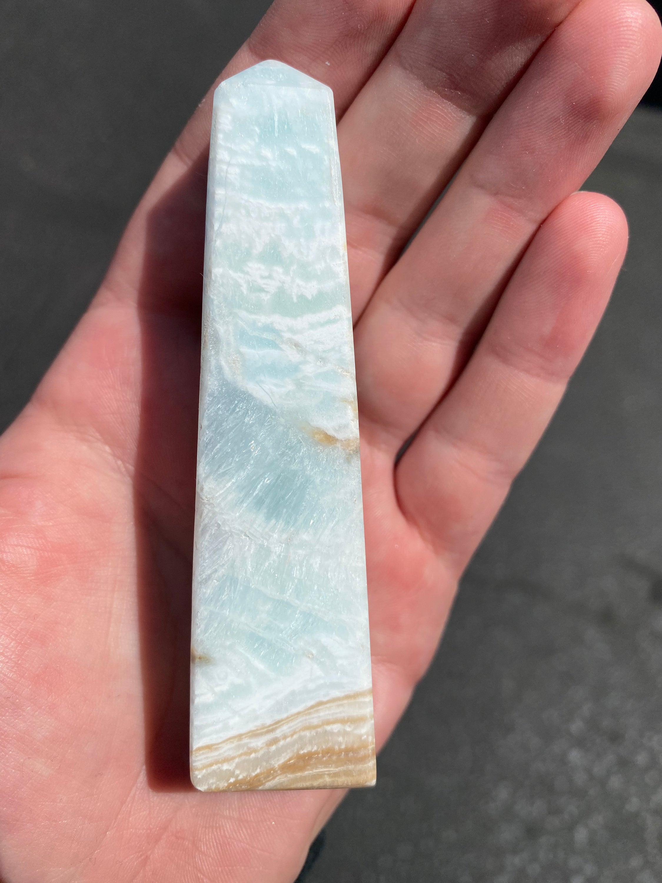 A beautifully crafted Caribbean Calcite Obelisk showcasing vibrant blue, green, and yellow colors, symbolizing tranquility and positive energy.