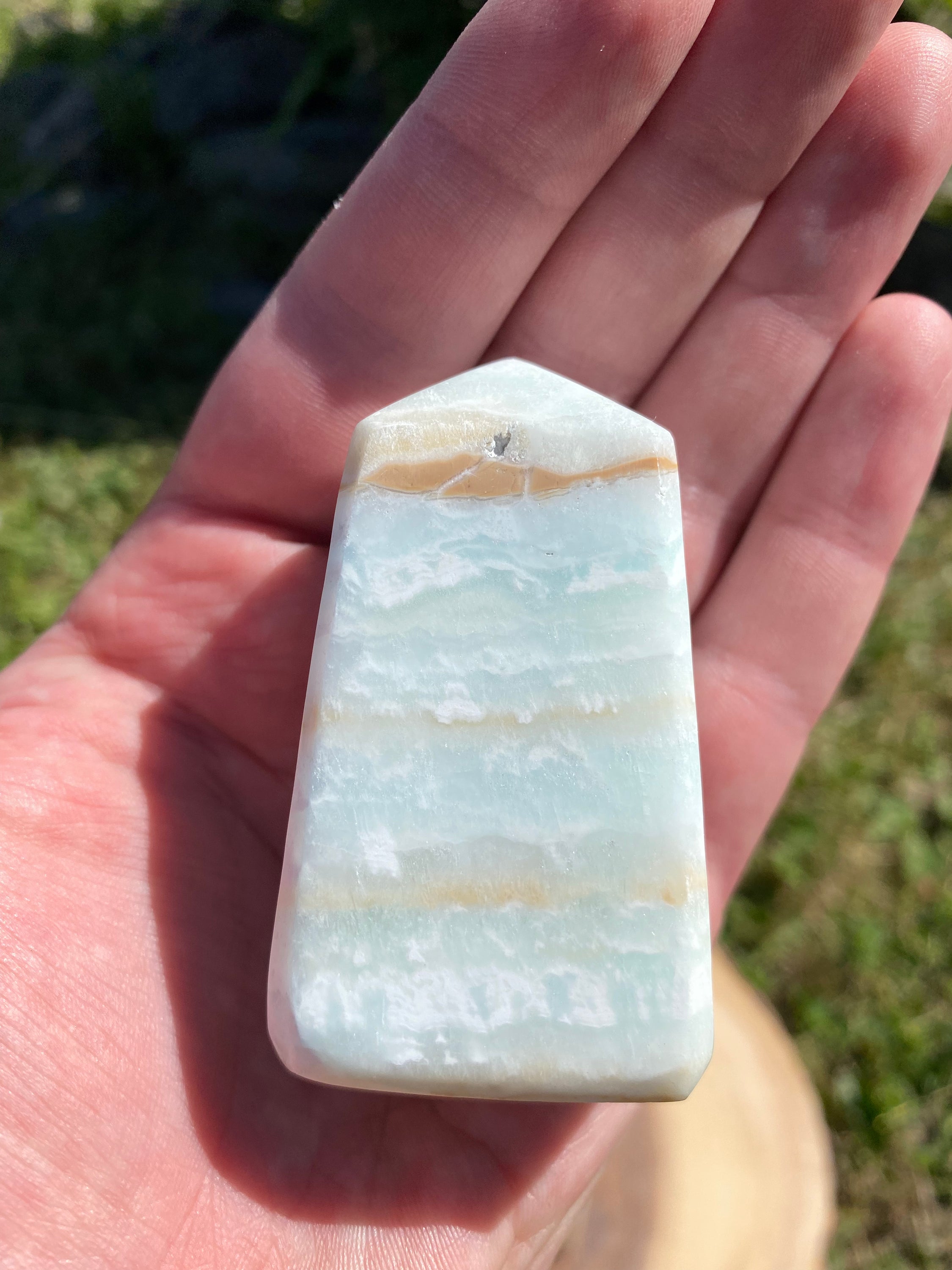 A beautifully crafted Caribbean Calcite Obelisk showcasing vibrant blue, green, and yellow colors, symbolizing tranquility and positive energy.