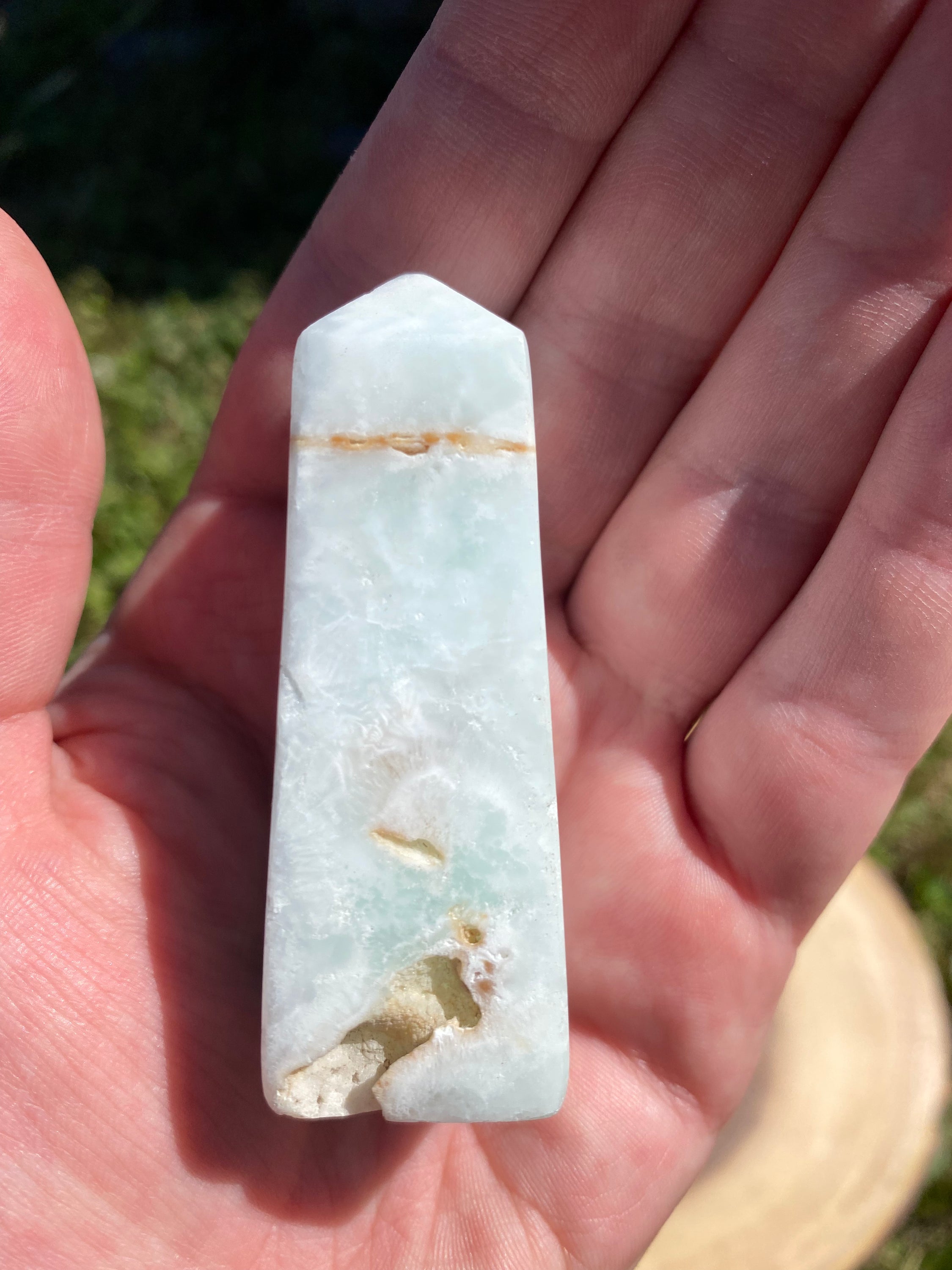 A beautifully crafted Caribbean Calcite Obelisk showcasing vibrant blue, green, and yellow colors, symbolizing tranquility and positive energy.