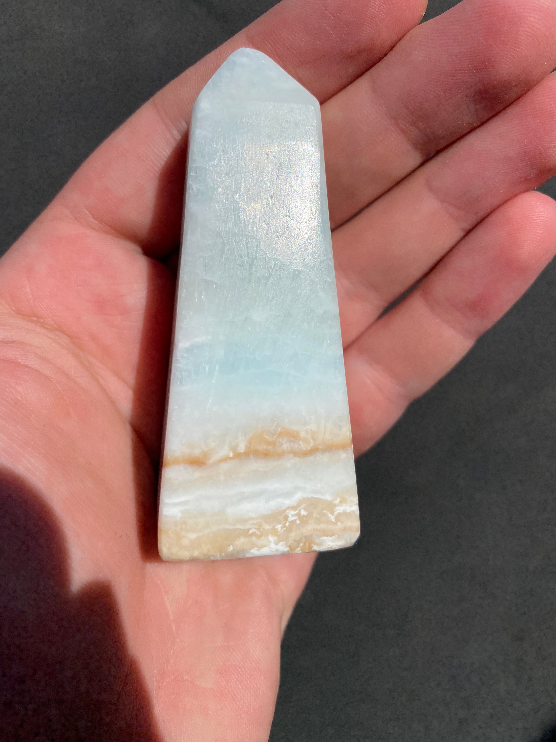 A beautifully crafted Caribbean Calcite Obelisk showcasing vibrant blue, green, and yellow colors, symbolizing tranquility and positive energy.