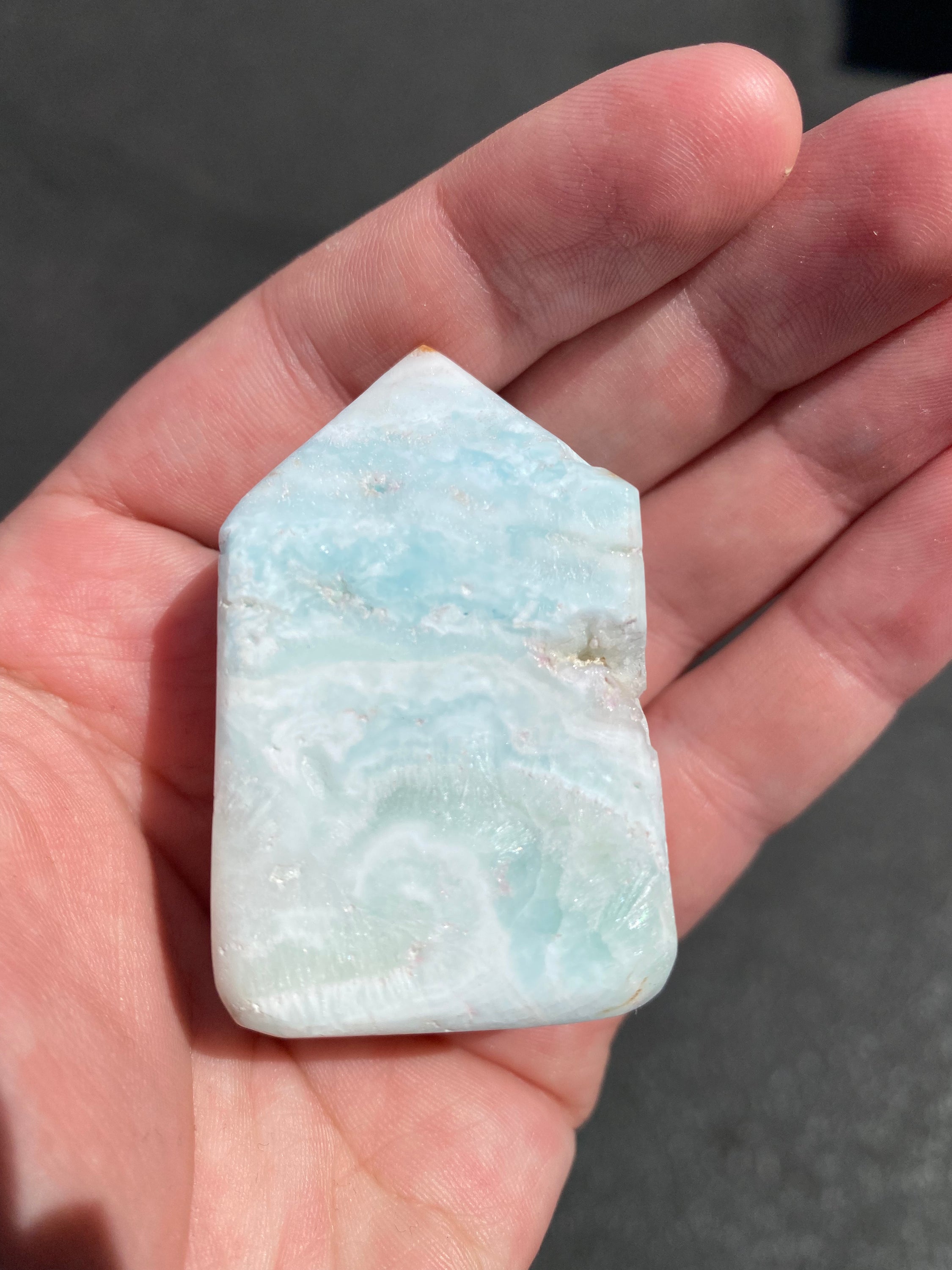 A beautifully crafted Caribbean Calcite Obelisk showcasing vibrant blue, green, and yellow colors, symbolizing tranquility and positive energy.