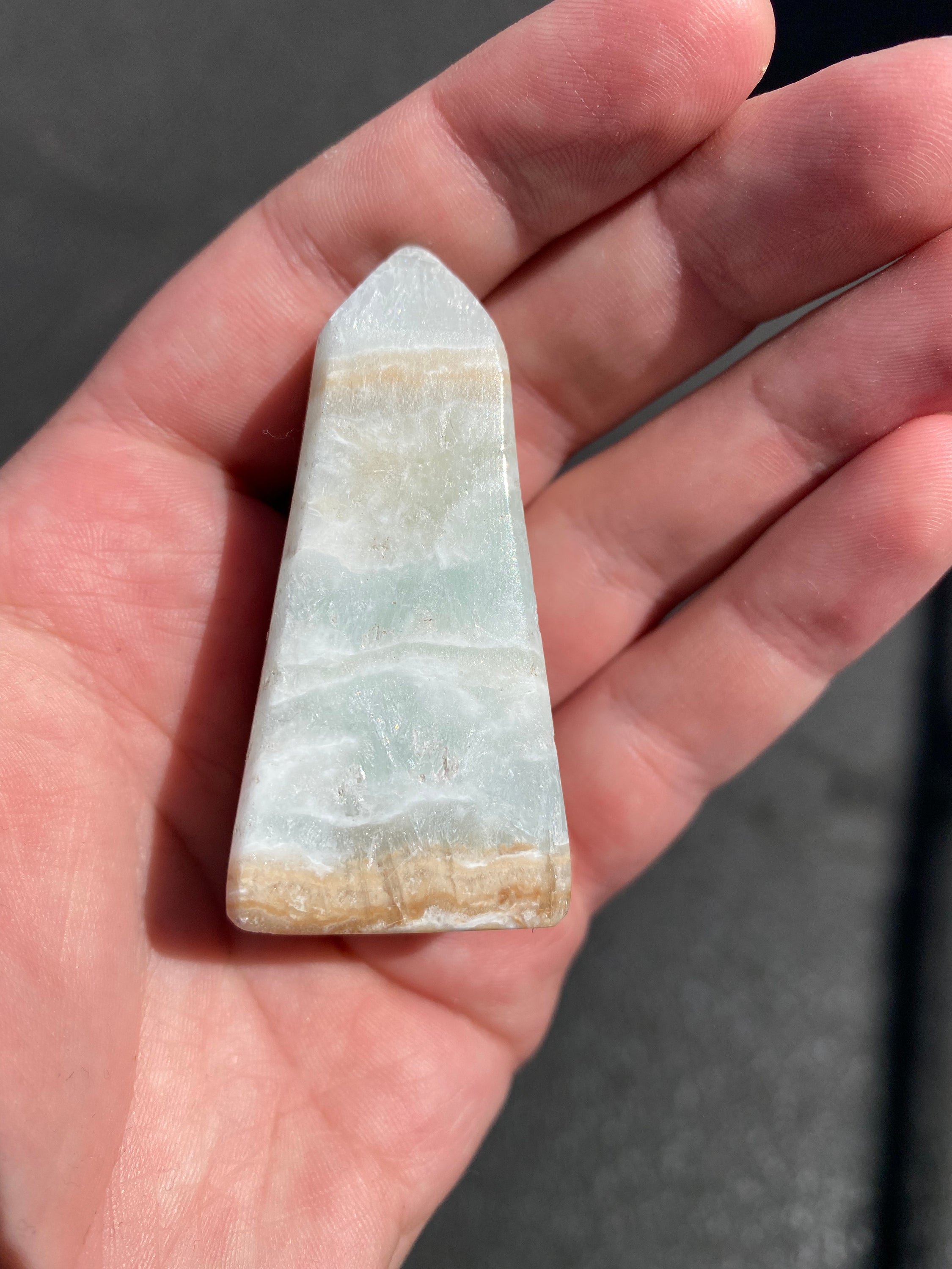 A beautifully crafted Caribbean Calcite Obelisk showcasing vibrant blue, green, and yellow colors, symbolizing tranquility and positive energy.