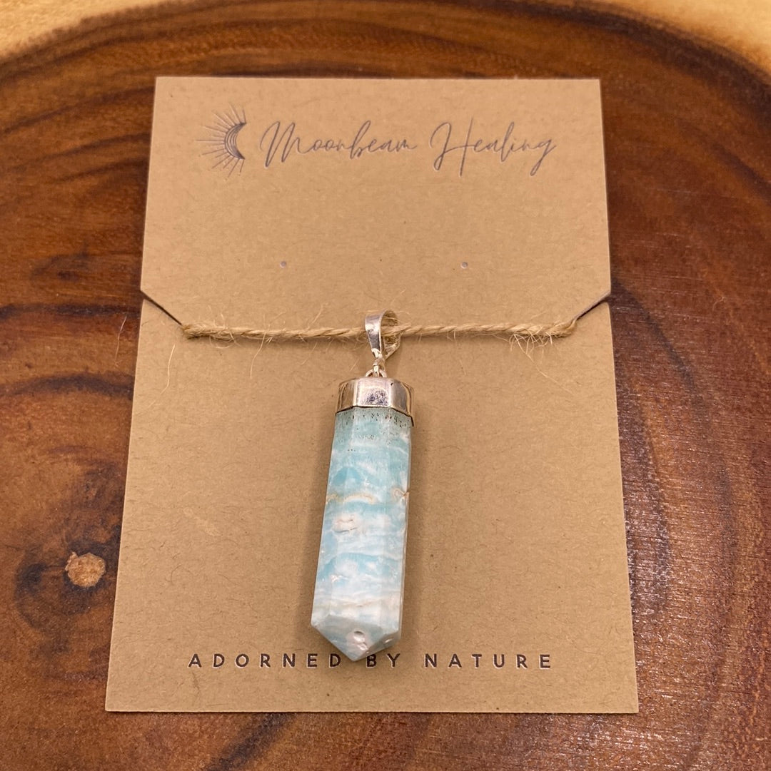 A beautiful Caribbean Calcite Pendant showcasing soft blue and white hues, symbolizing tranquility and positive energy.