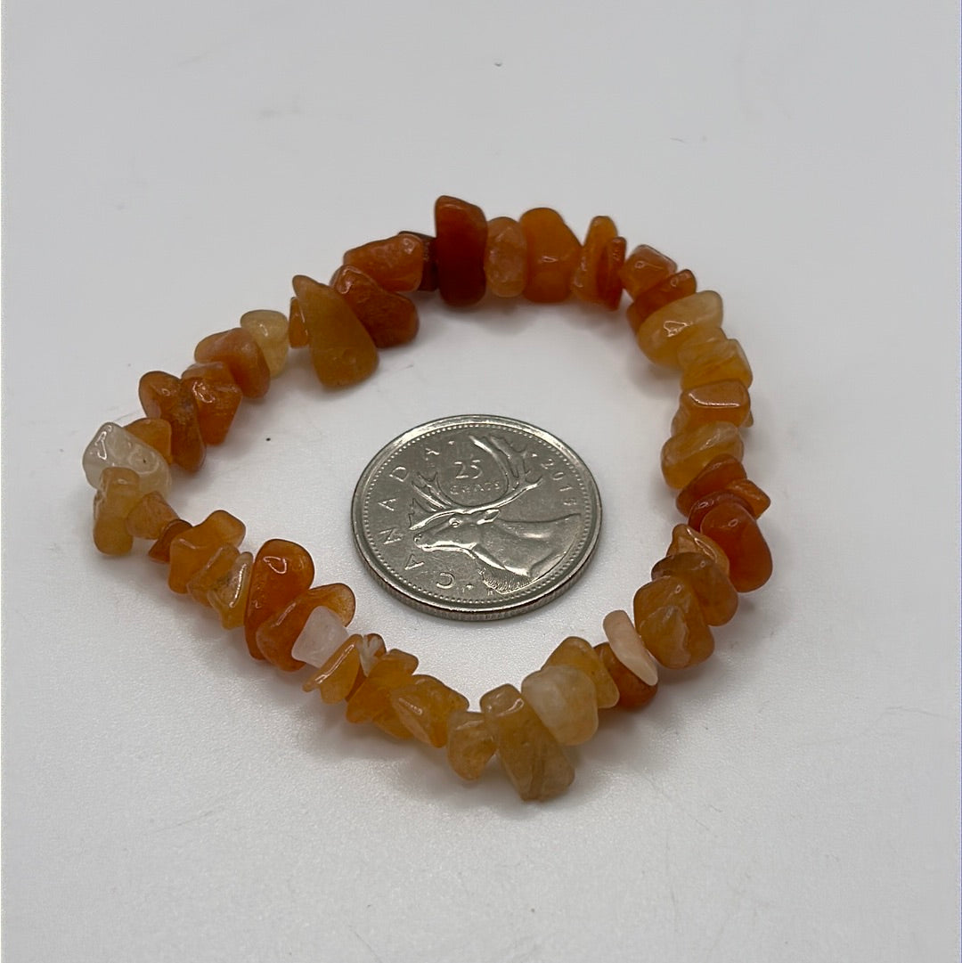 A stretchable bracelet made of vibrant carnelian chips in red and orange hues, symbolizing motivation and self-esteem.