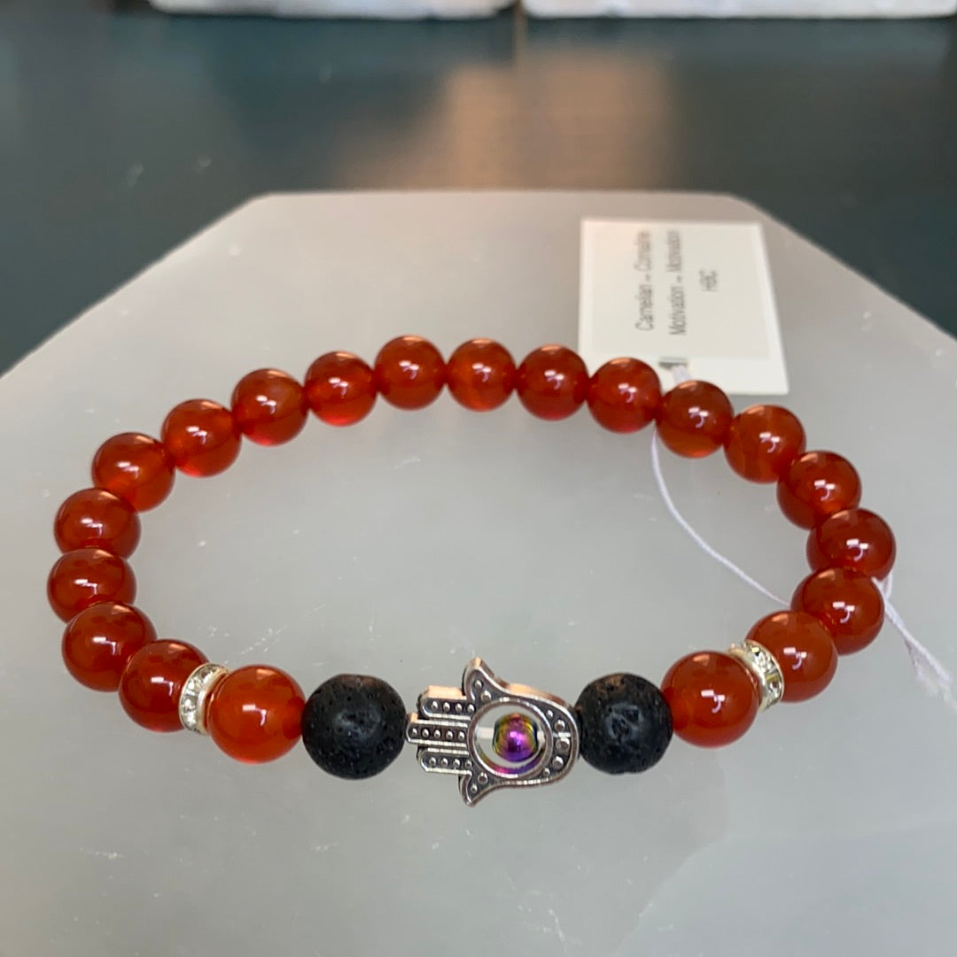 A stretchable Carnelian Hamsa Bracelet featuring vibrant carnelian stones, lava stone, and a protective hamsa hand symbol.