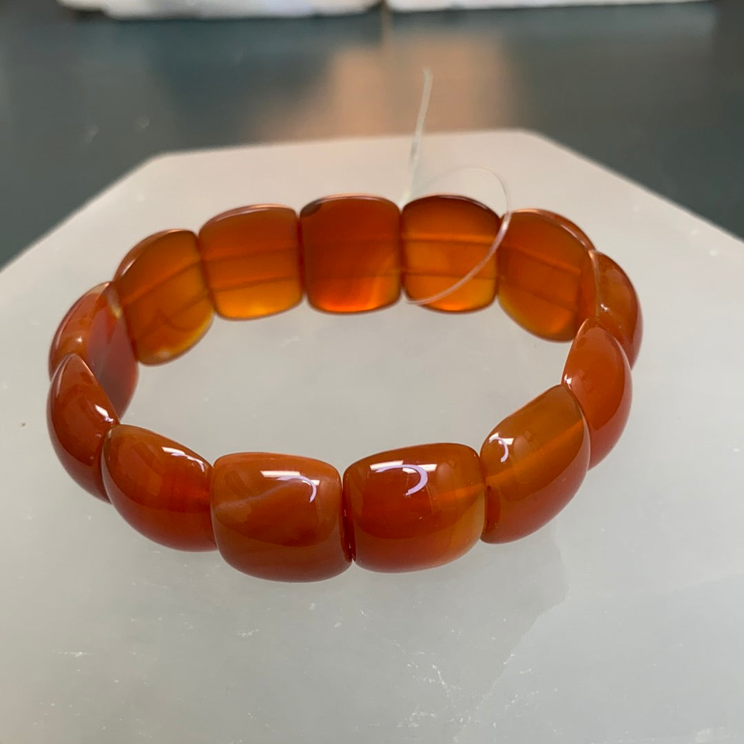 A stylish Carnelian Oval Beaded Bracelet featuring vibrant red and orange semi-precious stones, perfect for enhancing motivation and self-esteem.