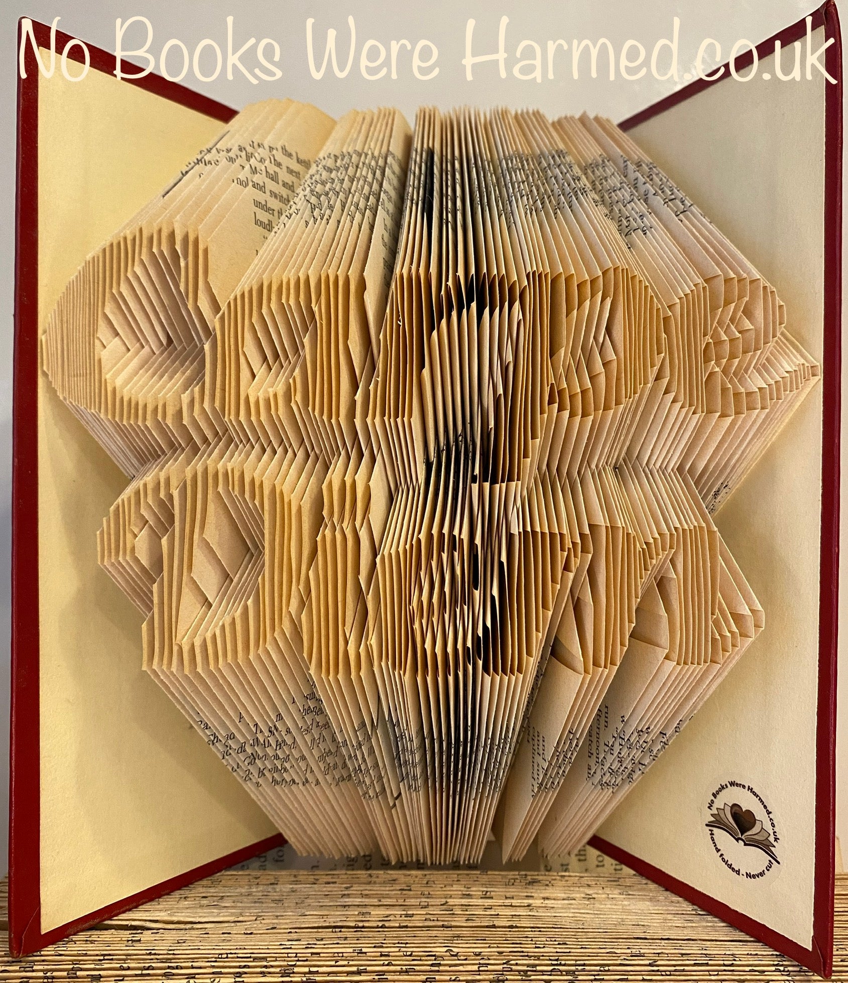 Handcrafted book art titled Carpe Diem, featuring intricately folded pages from vintage books, showcasing unique colors and designs.