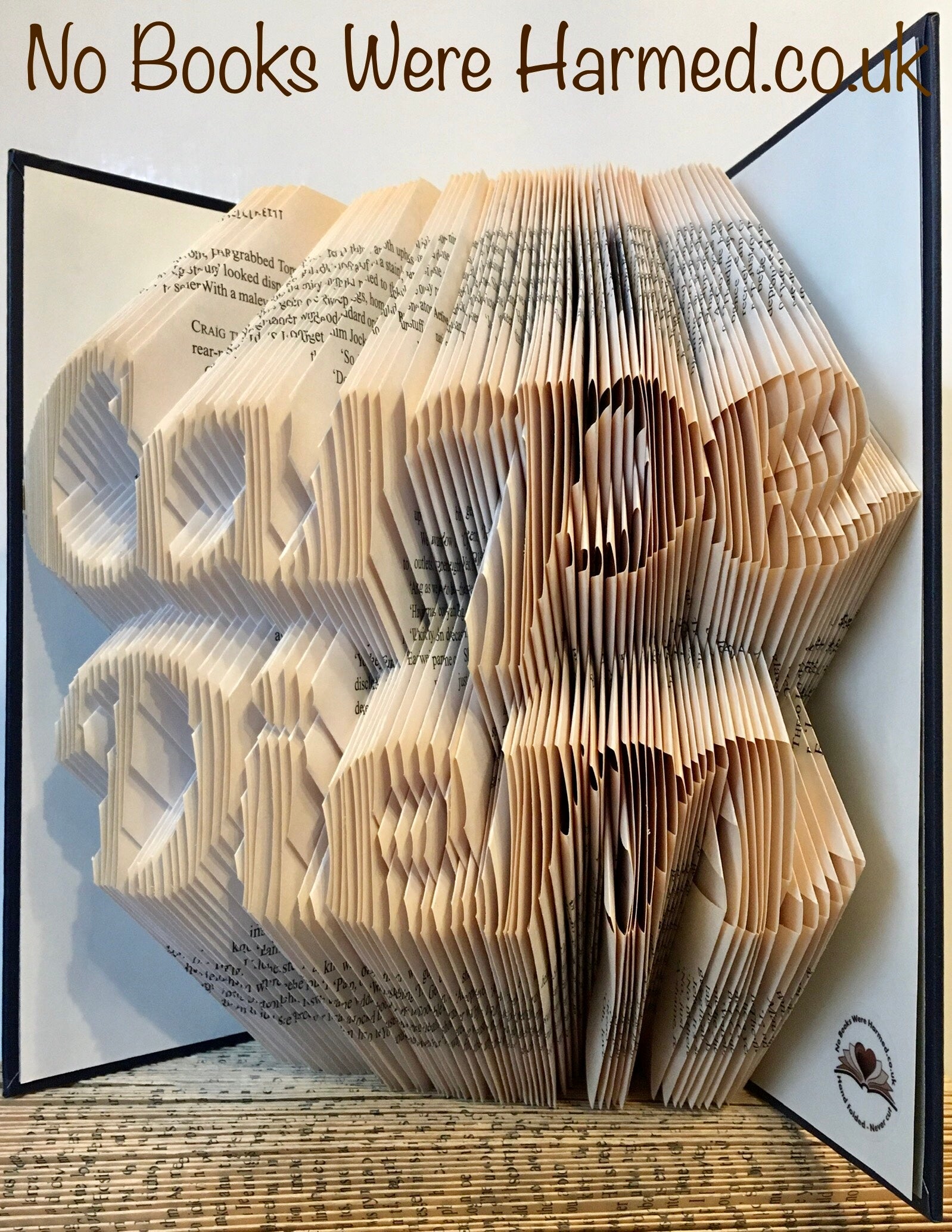 Handcrafted book art titled Carpe Diem, featuring intricately folded pages from vintage books, showcasing unique colors and designs.