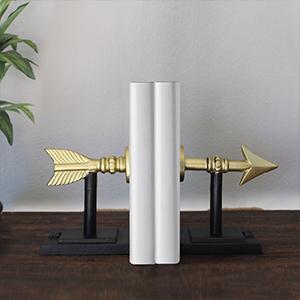 Stylish cast iron arrow bookends in gold and black, measuring 7 inches tall, elegantly holding books on a shelf.