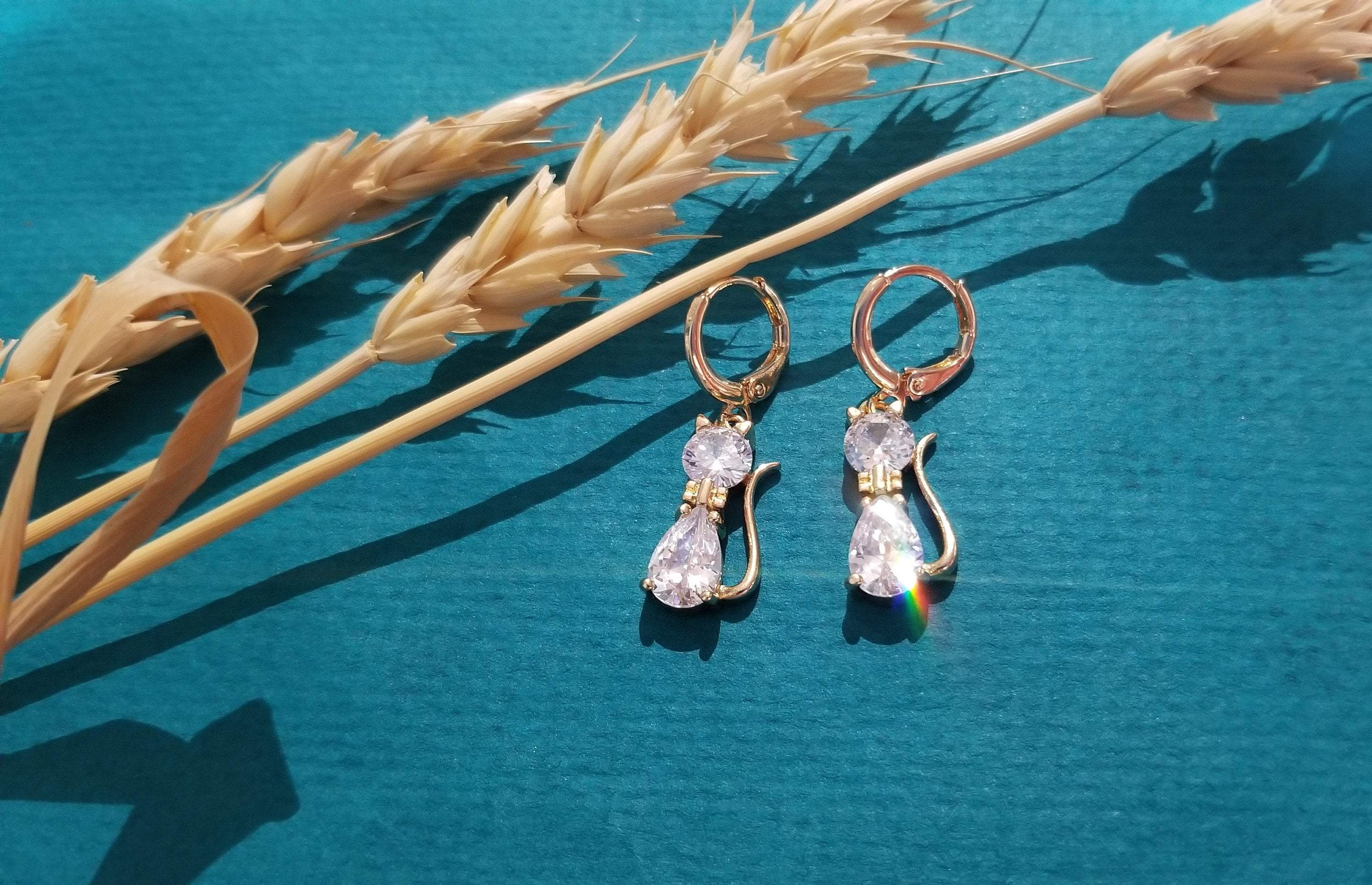 A pair of elegant cat drop hoop earrings featuring clear crystal stones, perfect for cat lovers.