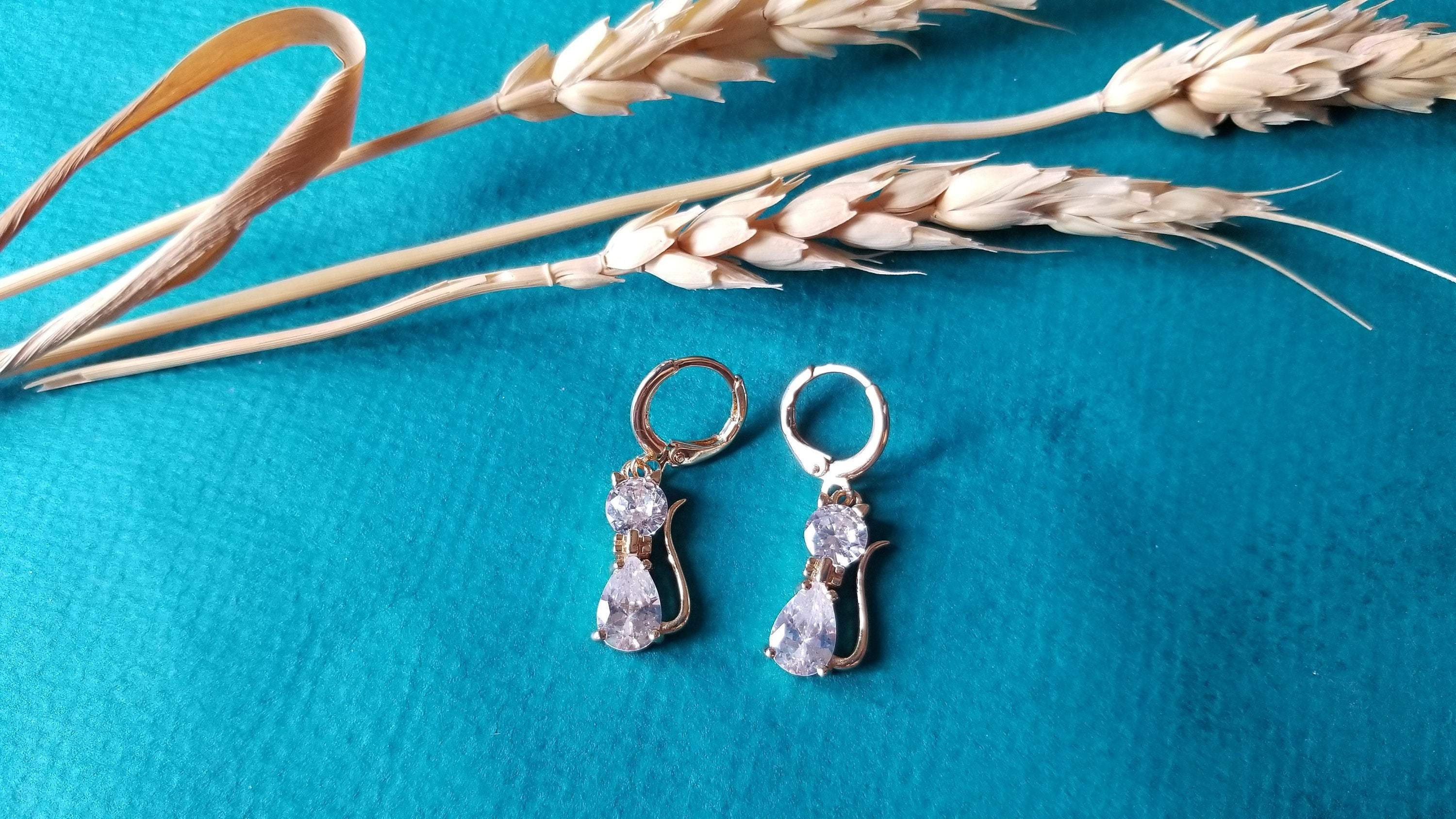 A pair of elegant cat drop hoop earrings featuring clear crystal stones, perfect for cat lovers.