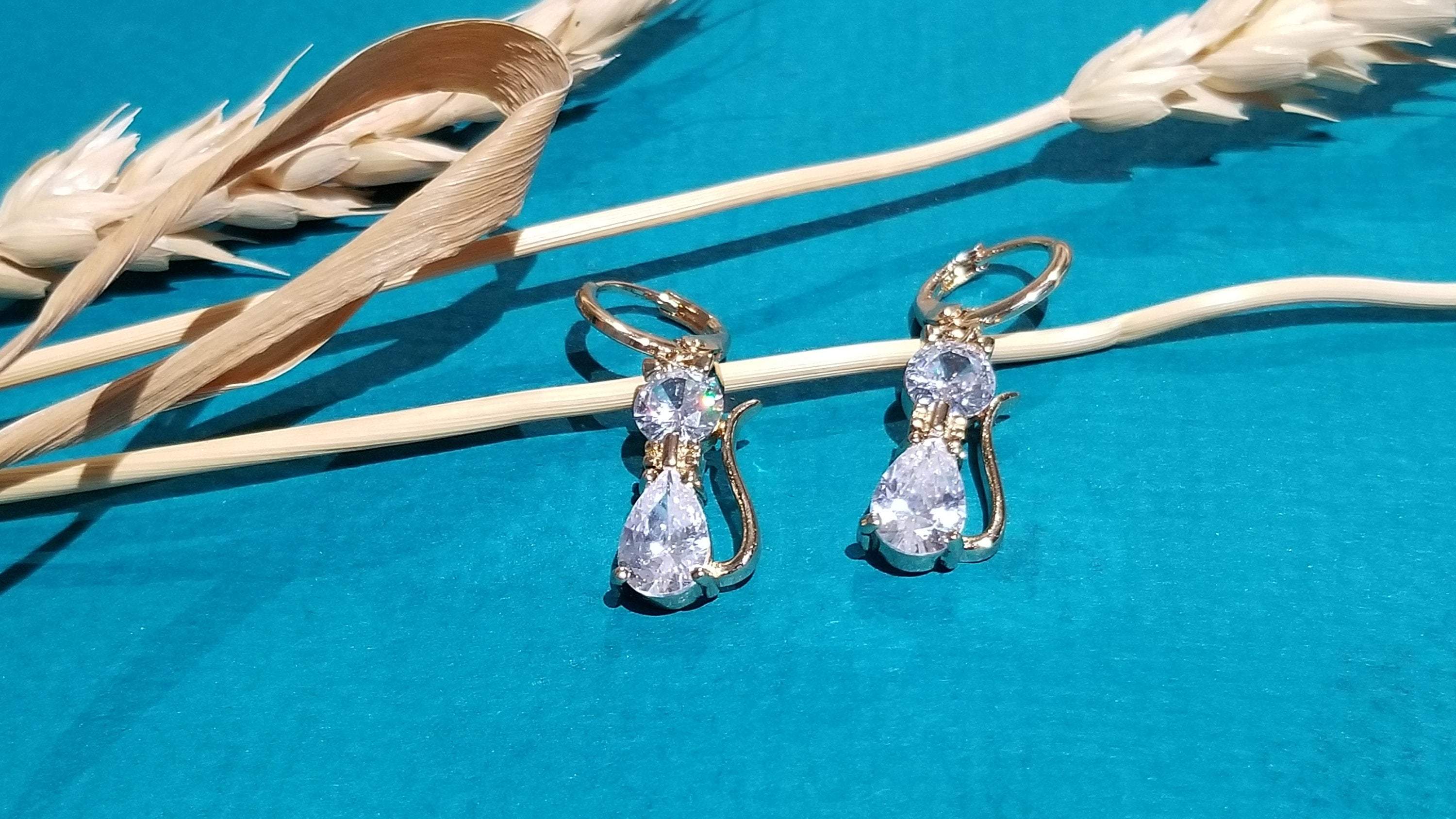 A pair of elegant cat drop hoop earrings featuring clear crystal stones, perfect for cat lovers.