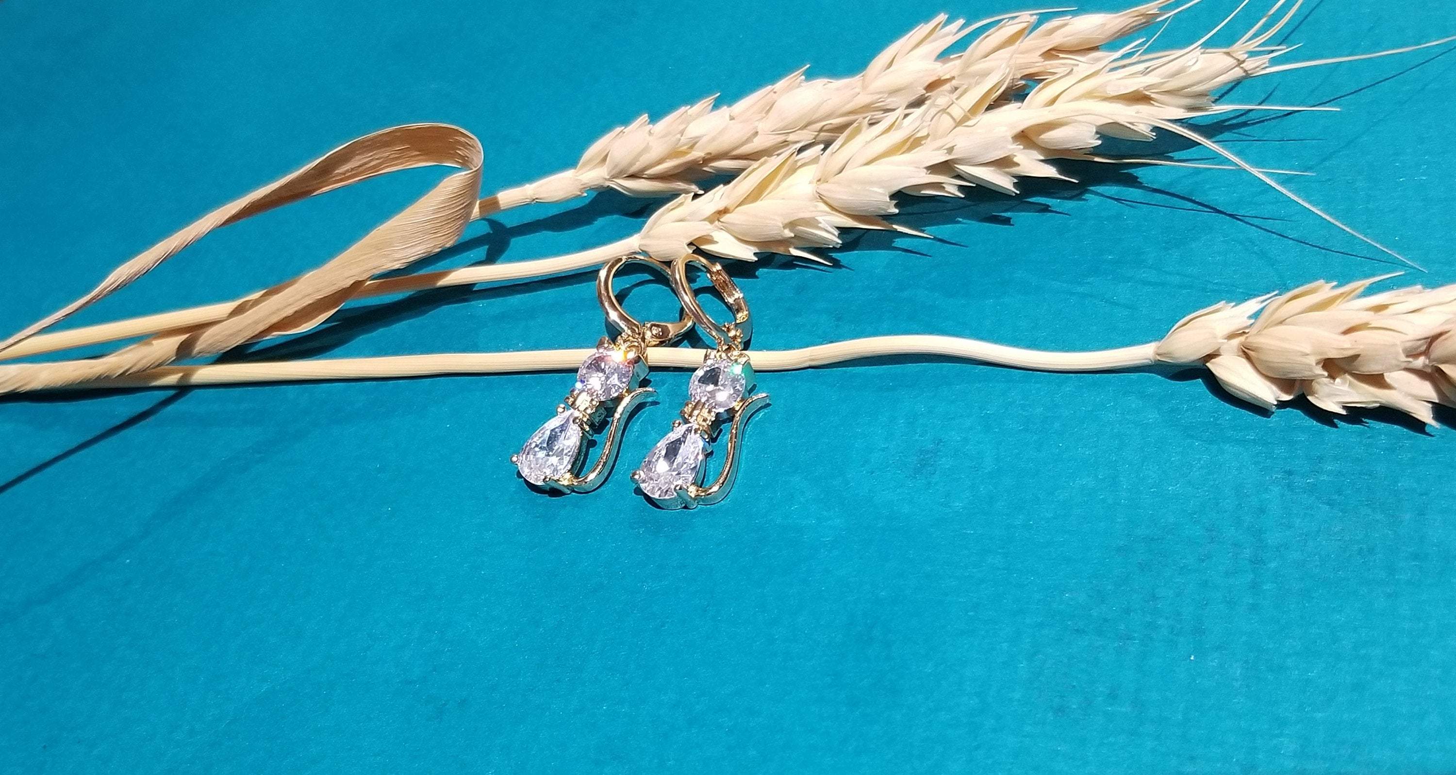 A pair of elegant cat drop hoop earrings featuring clear crystal stones, perfect for cat lovers.