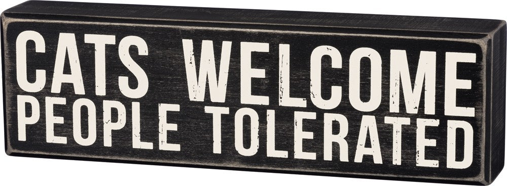 A rustic black and white wooden box sign that reads 'Cats Welcome - People Tolerated', featuring a distressed finish.