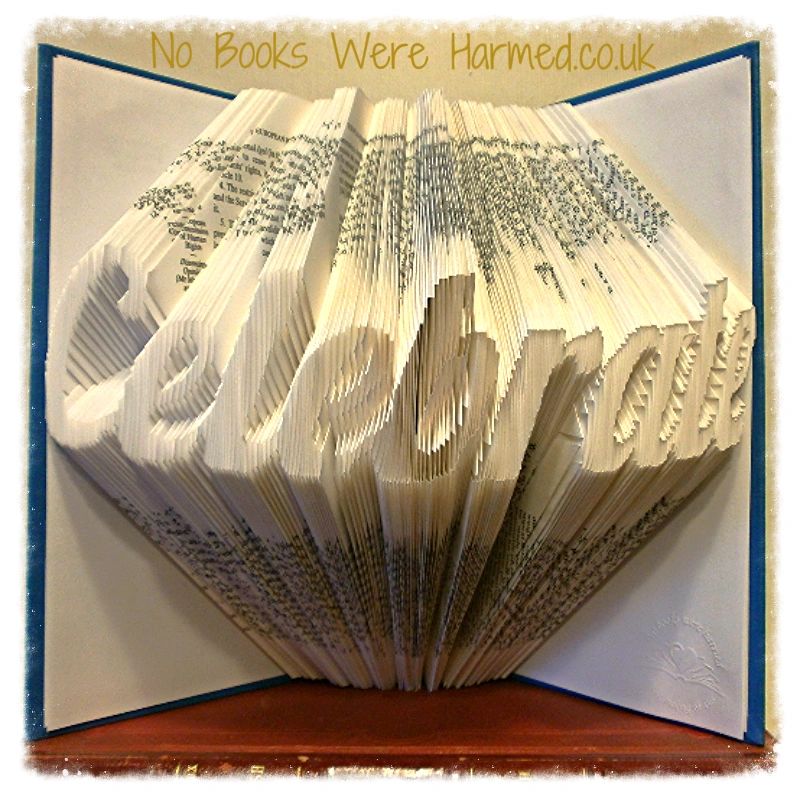 A unique piece of hand-folded book art made from vintage books, showcasing intricate designs and textures.