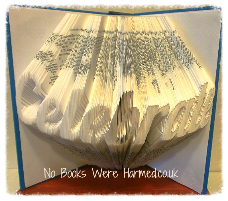 A unique piece of hand-folded book art made from vintage books, showcasing intricate designs and textures.