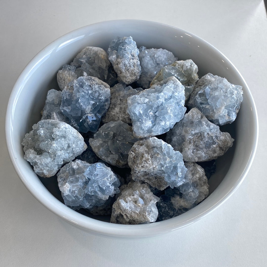 A collection of small Celestite mini geode clusters showcasing their beautiful blue color and unique formations.