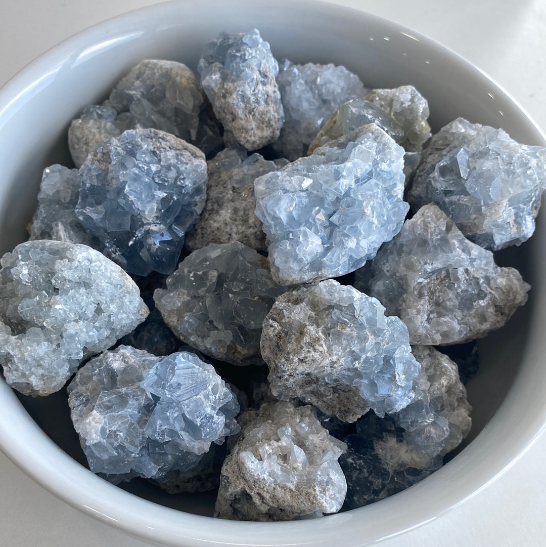 A collection of small Celestite mini geode clusters showcasing their beautiful blue color and unique formations.